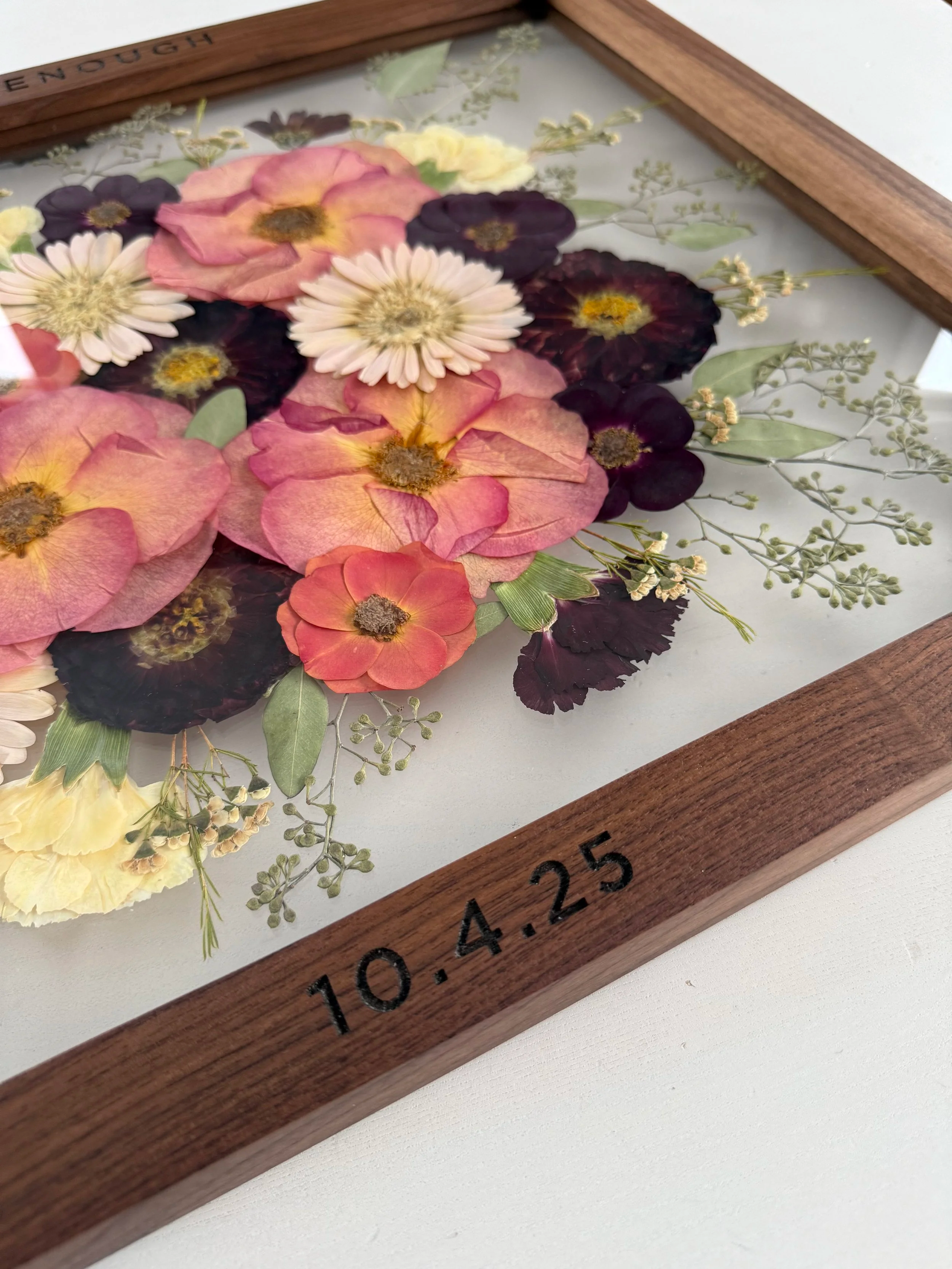 Pressed flowers framed with date engraved on the frame.