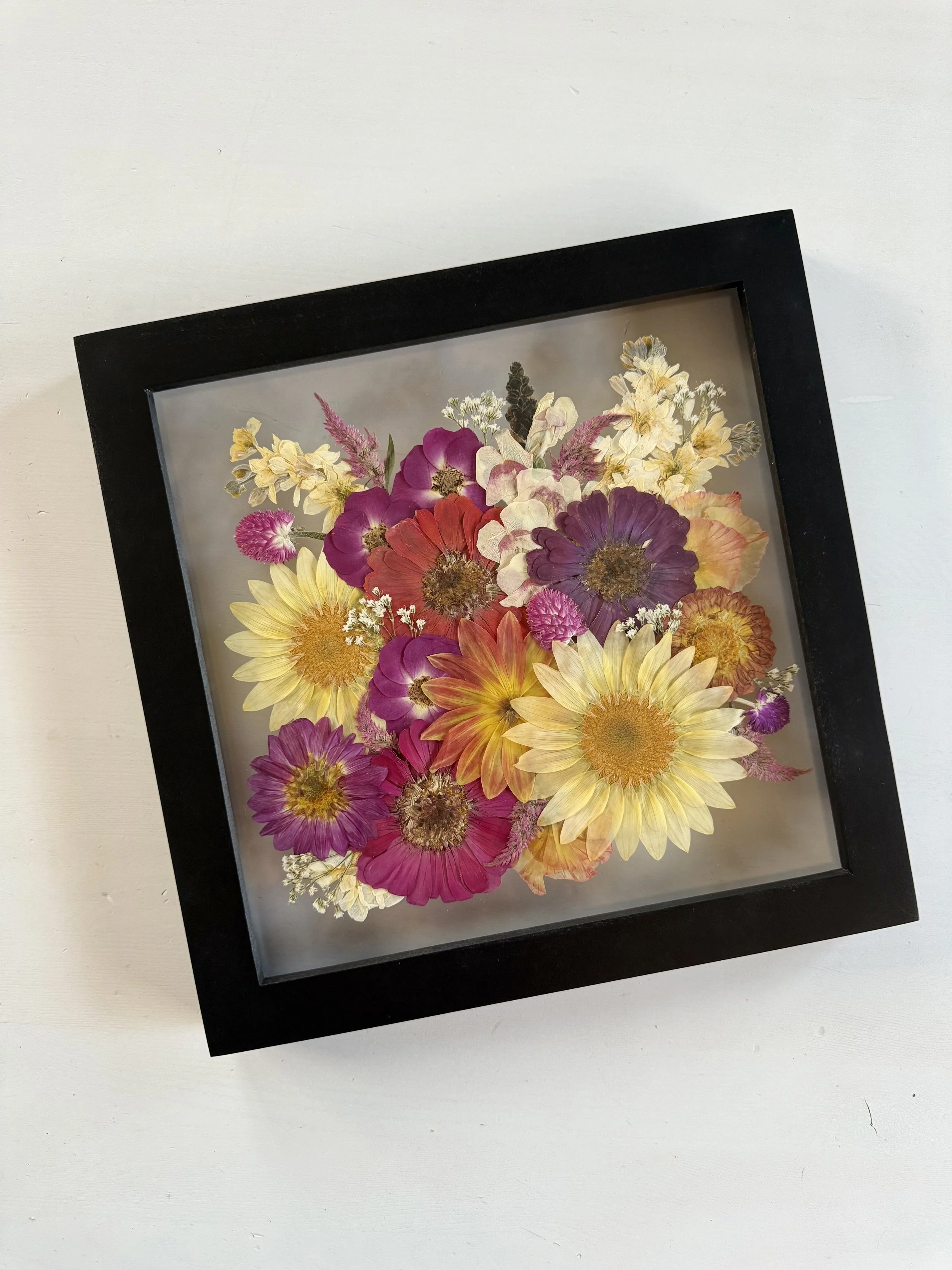 Pink and yellow bridal bouquet pressed and preserved in a 12x12 wood frame.