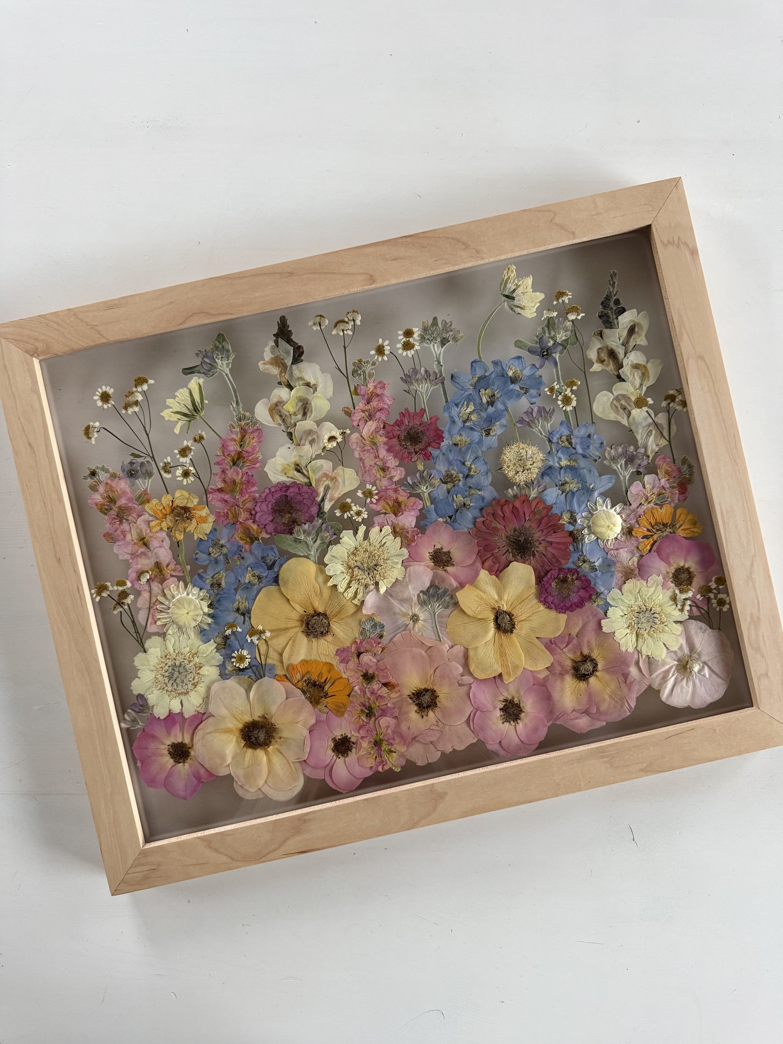 Summer bridal bouquet, pressed and preserved in a frame with a meadow design.