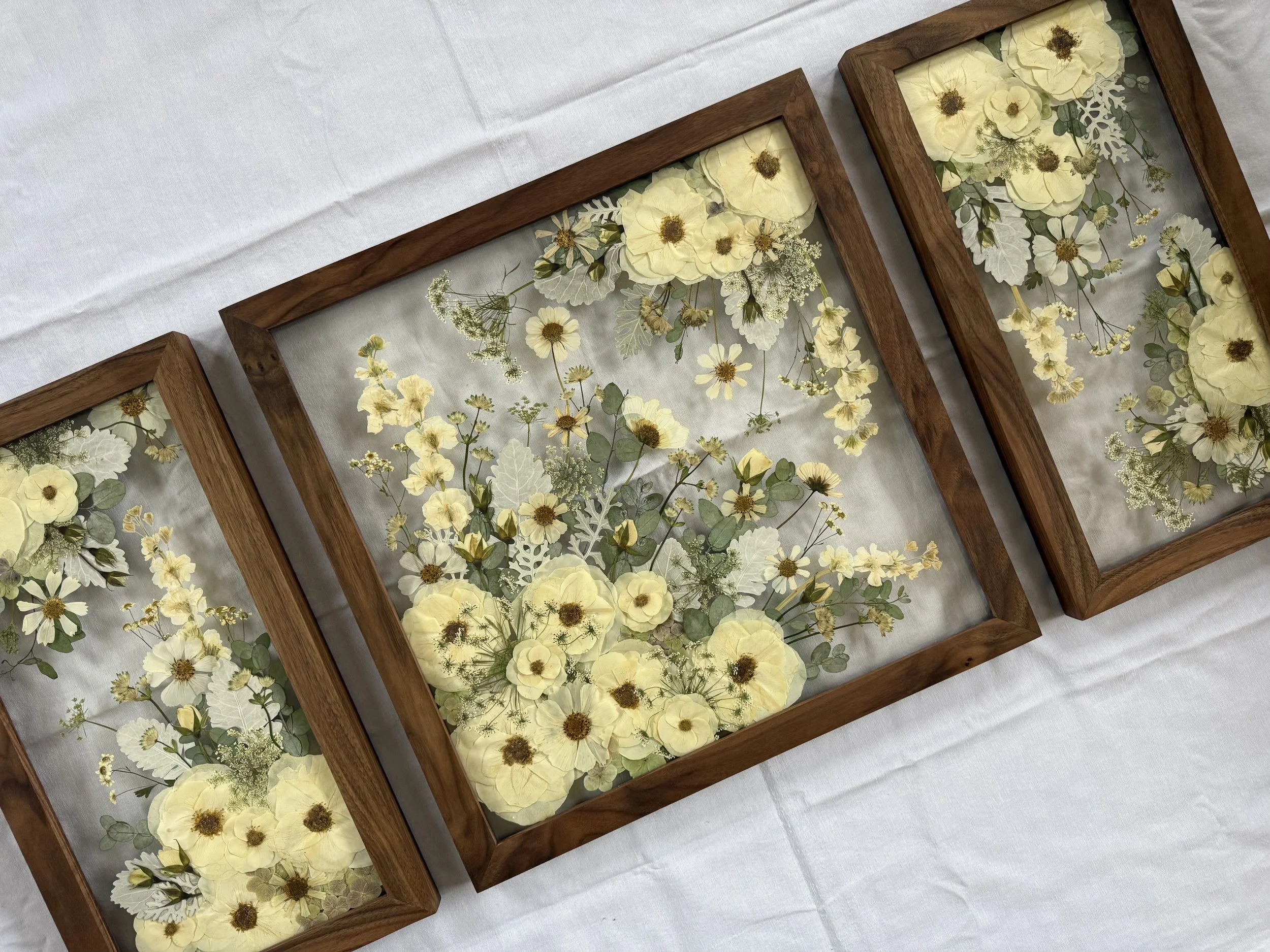 Pressed and preserved flowers that are framed and form a gallery wall.