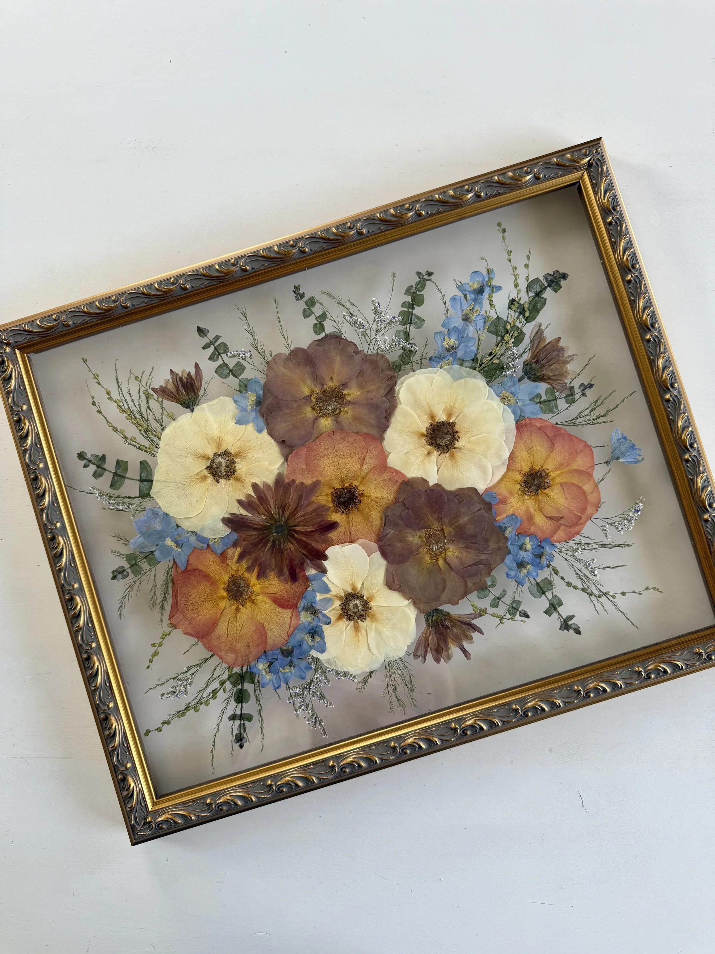 Mocha and orange bridal bouquet flowers, pressed and framed in a bouquet design.