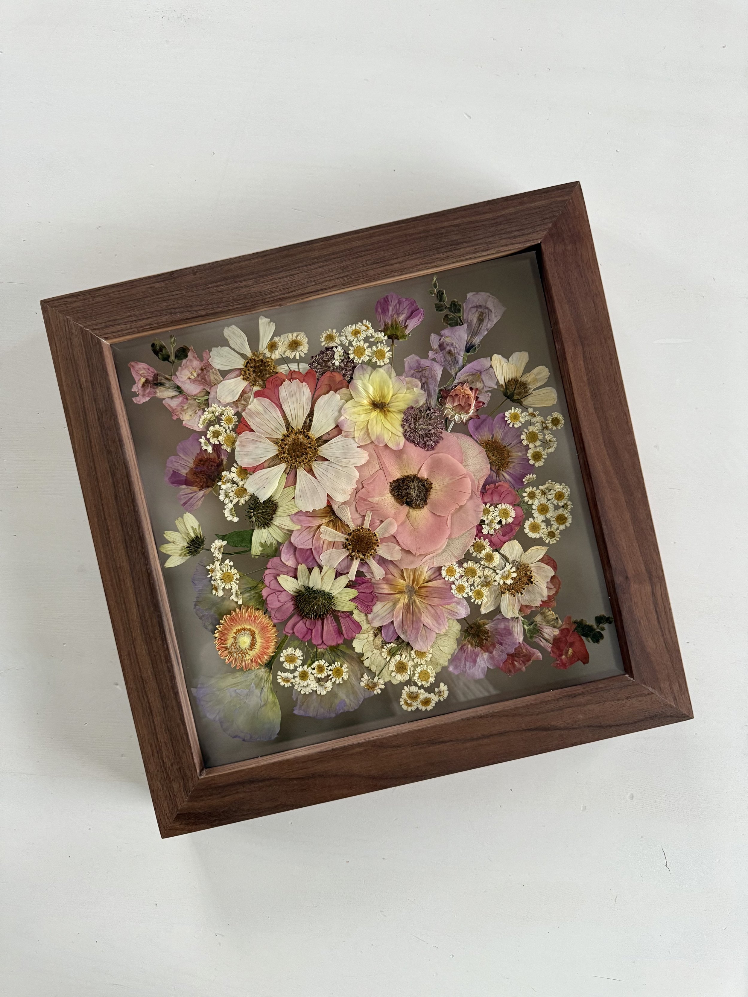 Zinnias, cosmos, and summer bridal bouquet flowers, pressed and framed in a bouquet design.