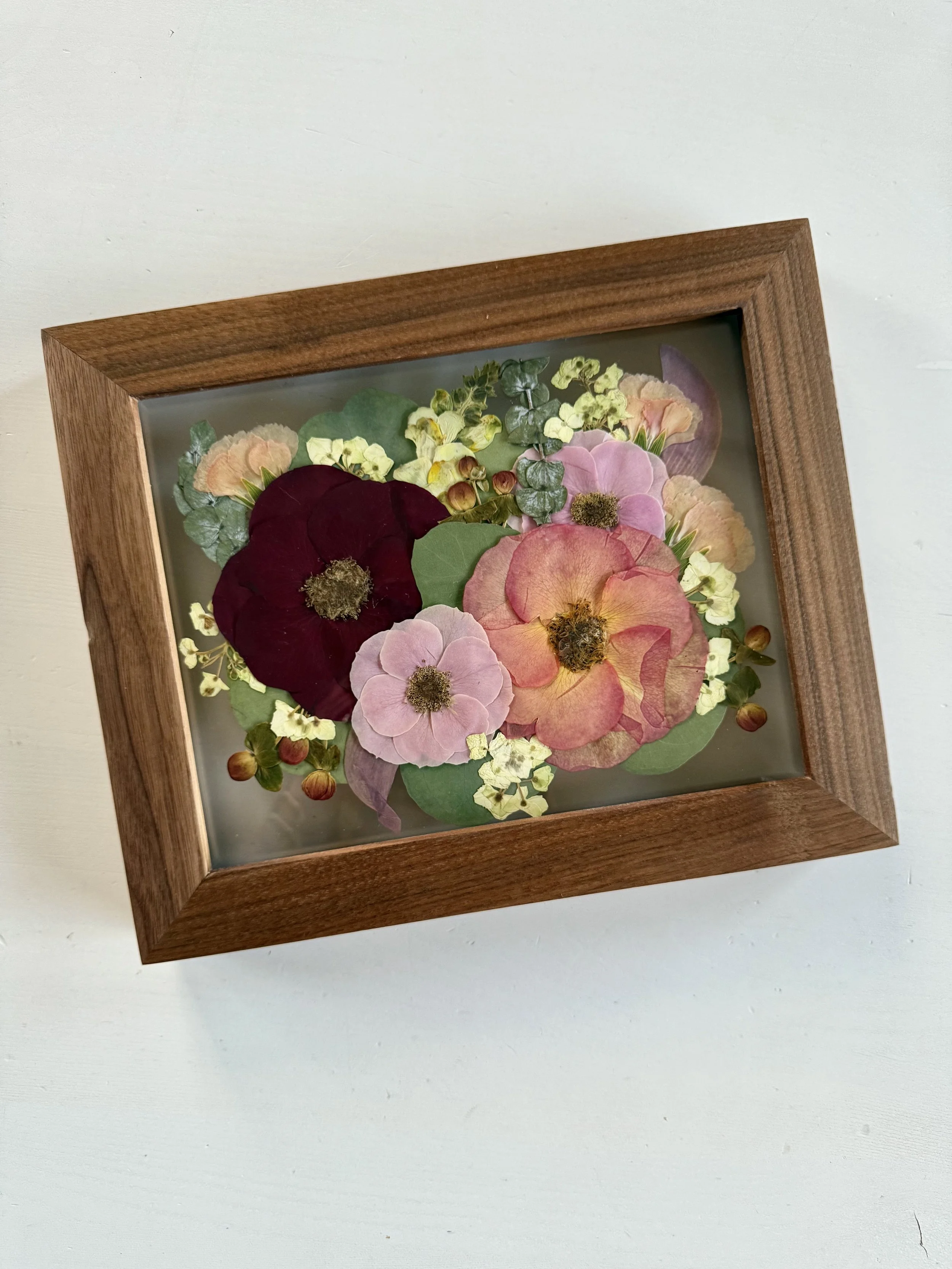Moody bridal bouquet pressed and preserved in an 8x10 wood frame.