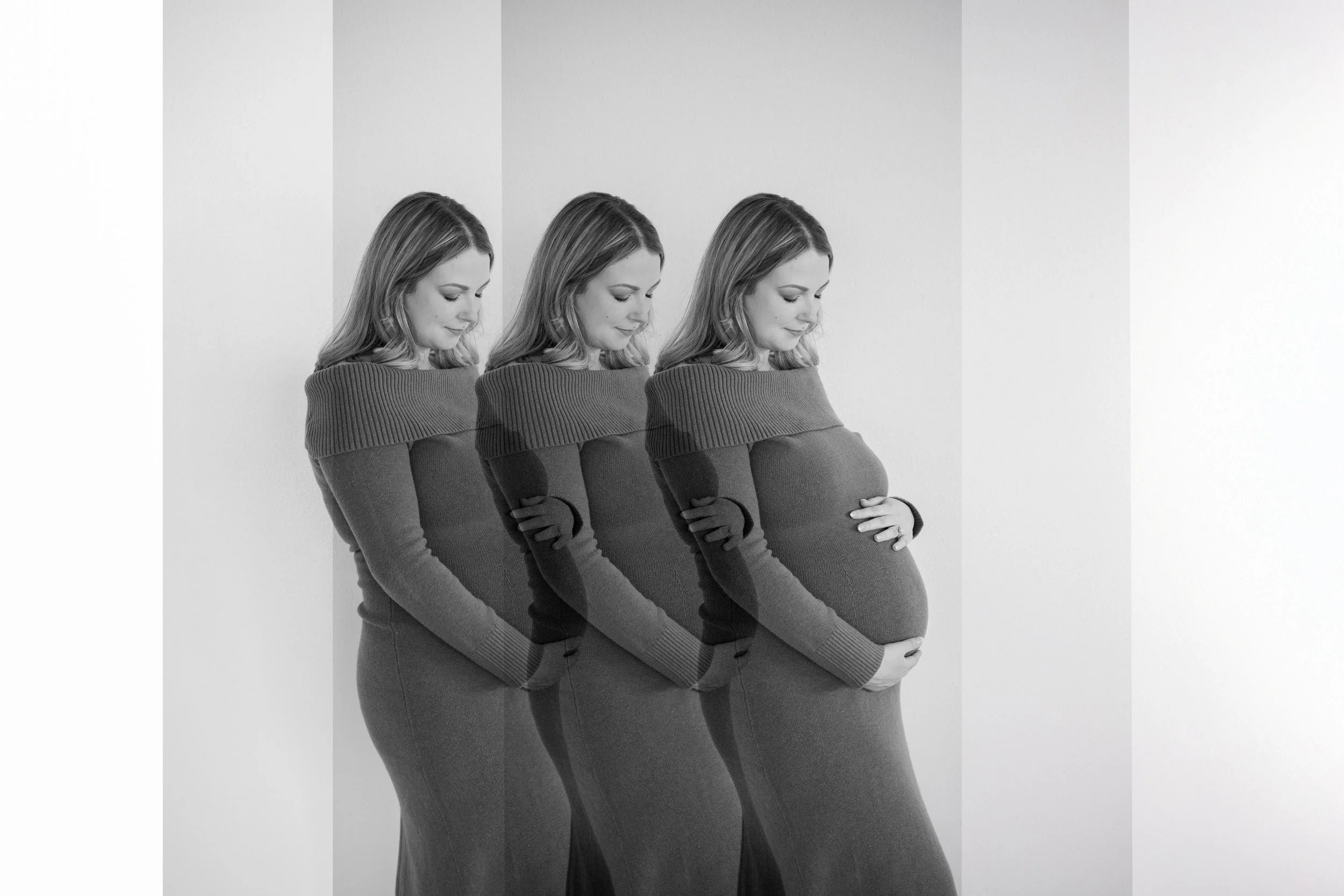 A black and white photo of a pregnant woman standing in front of a plain background, shown three times in varying opacities, with her hands resting on her belly, smiling gently with her eyes closed.