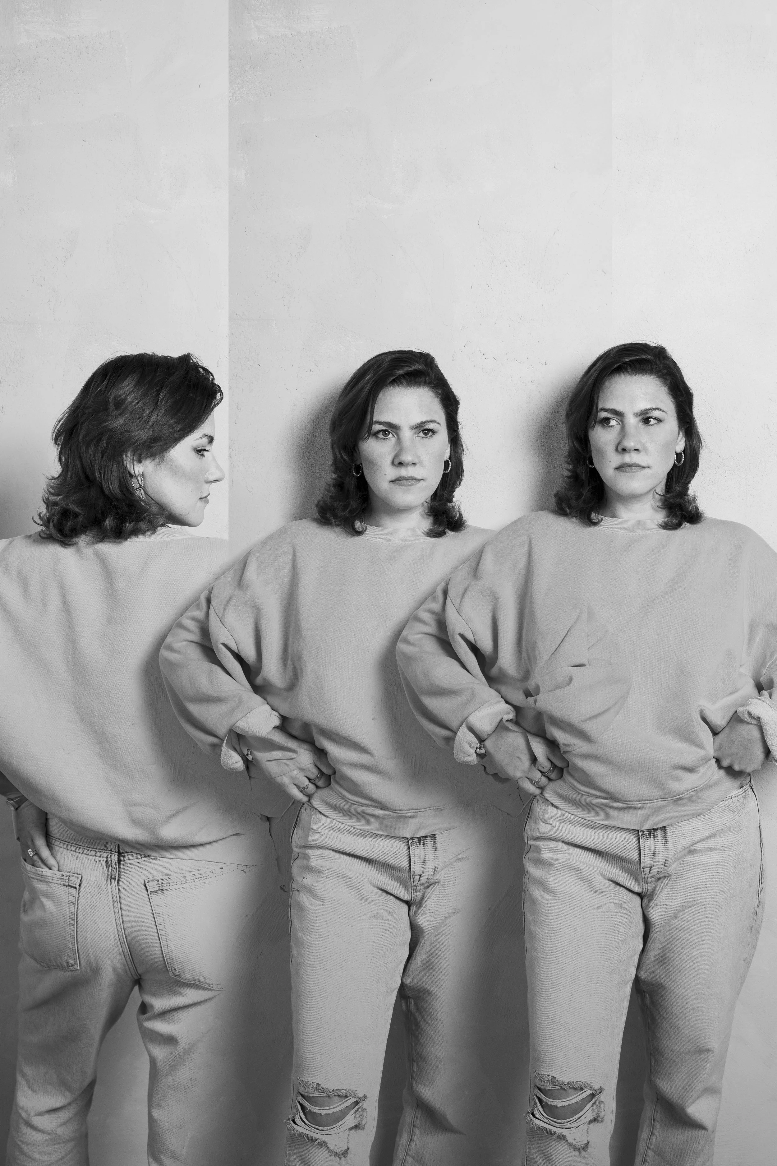 Black and white photo of a woman in three different poses: looking to the side, facing forward with hands on hips, and looking to the side again, all wearing a sweatshirt and jeans.