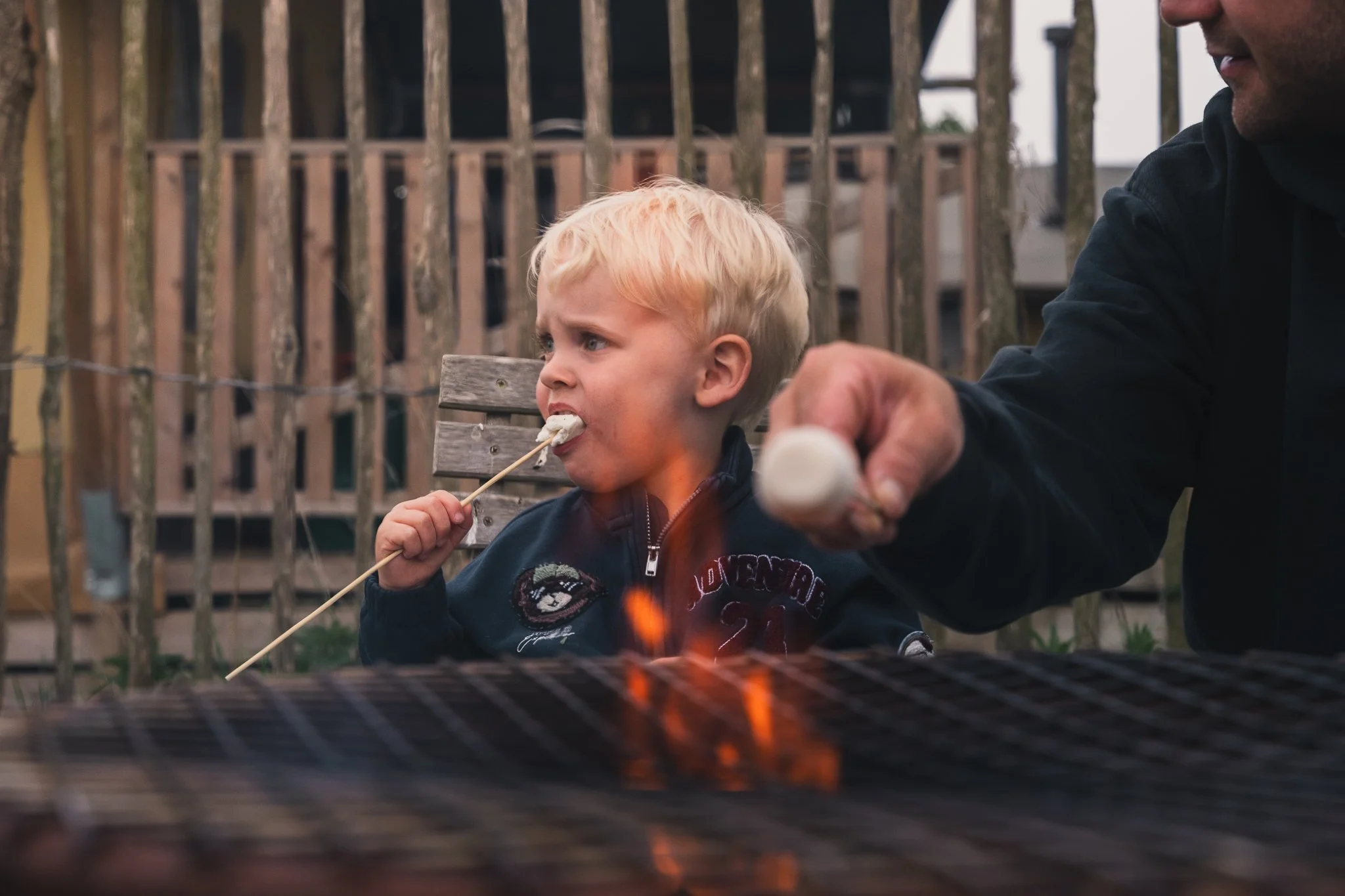 little boy with marshmallow by the firepit