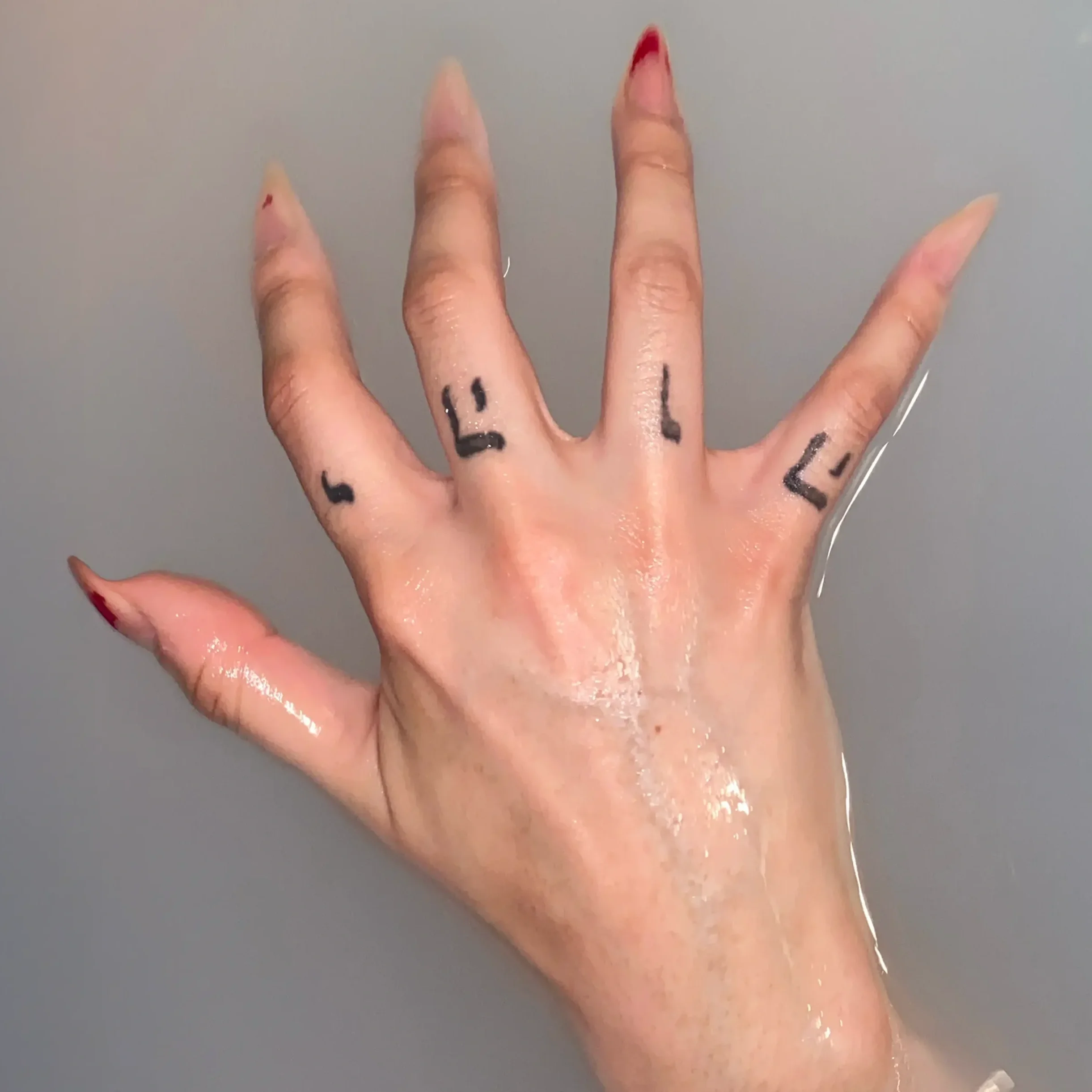 Manic Pixie Nightmare cover art by Jehovah's Princess featuring hand with long nails and Hebrew letters YHWH tattooed in murky water