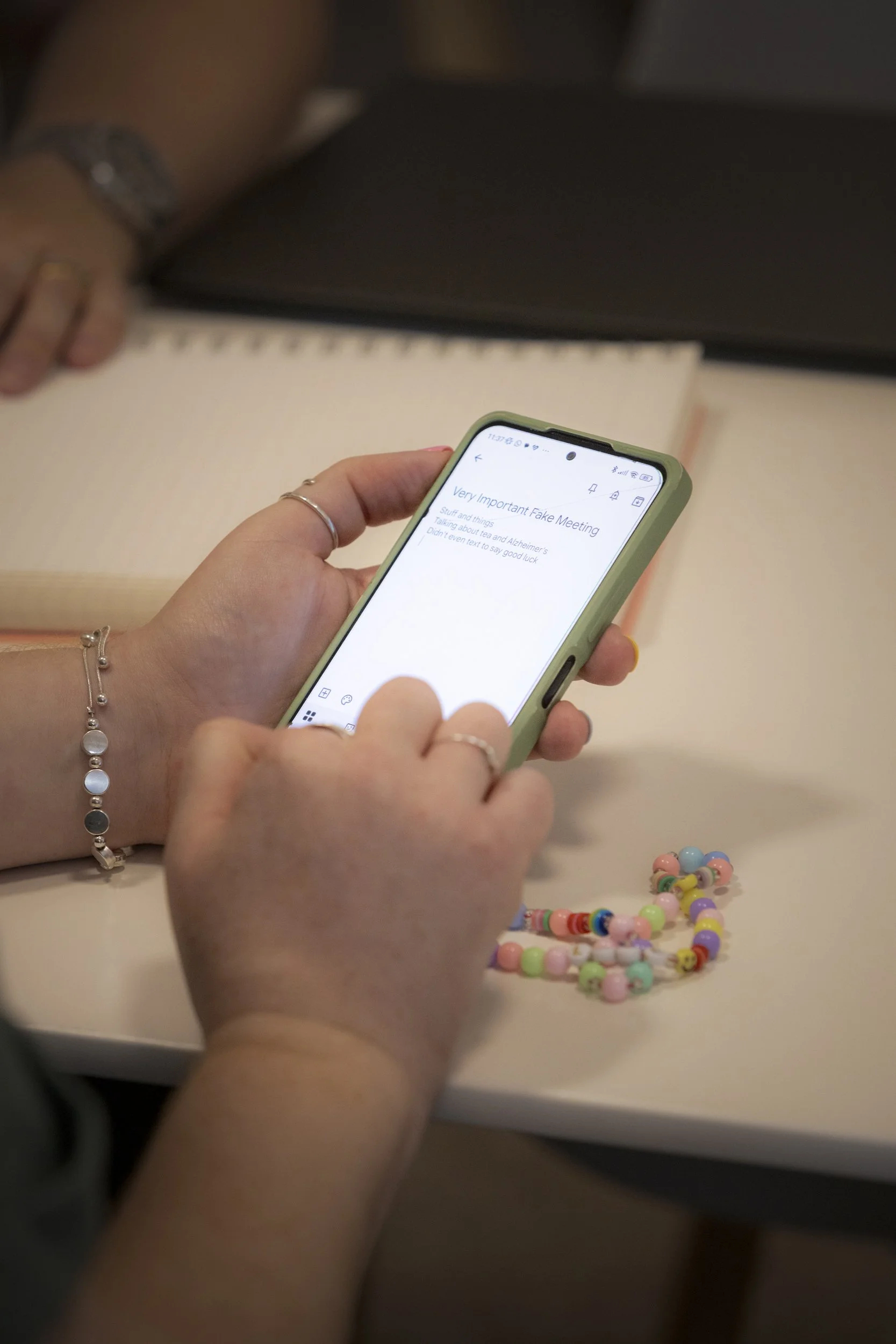 Close up image of someone using a smartphone with a green case.
