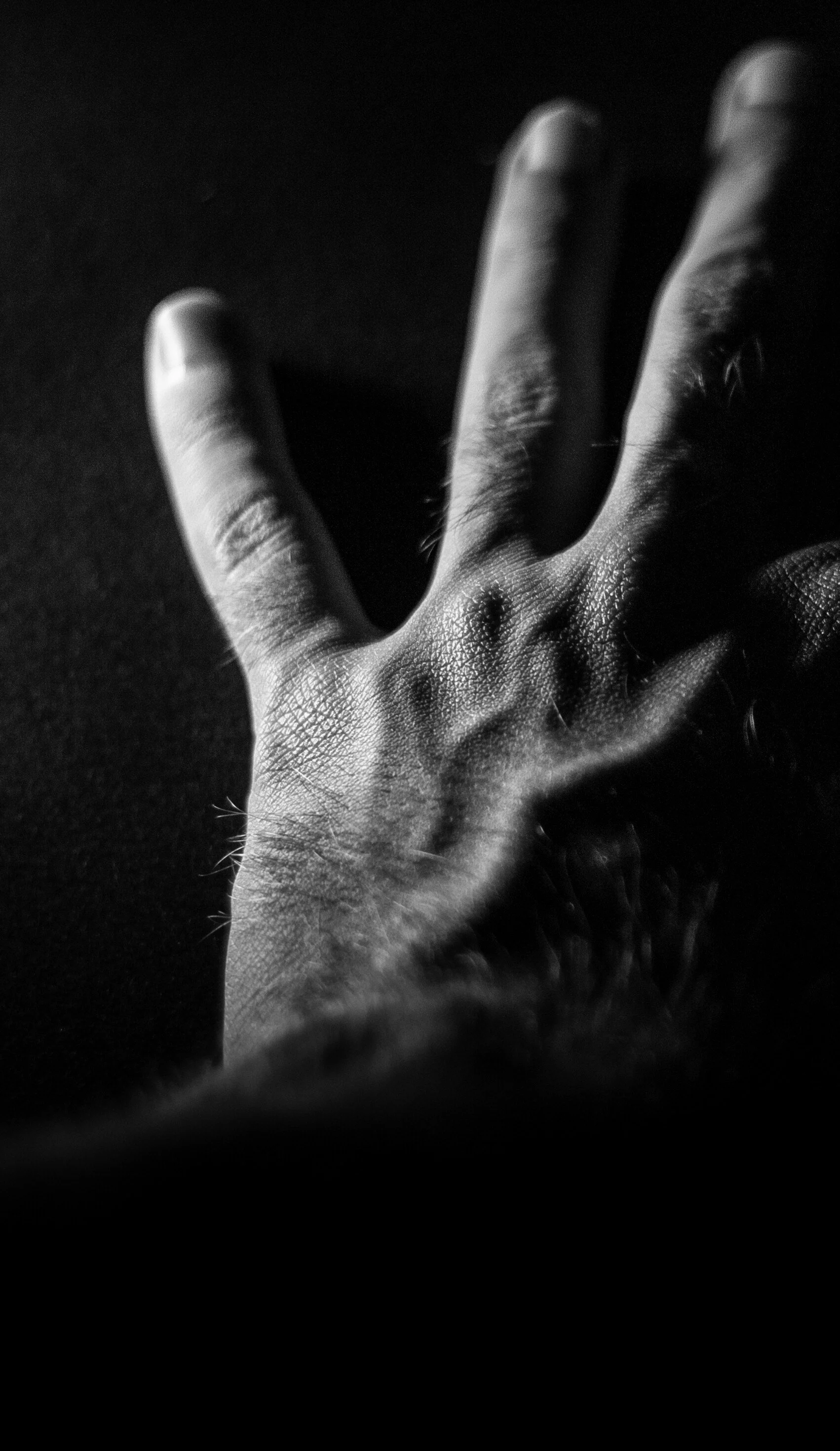 Black and white photo of a hand with veins popping up