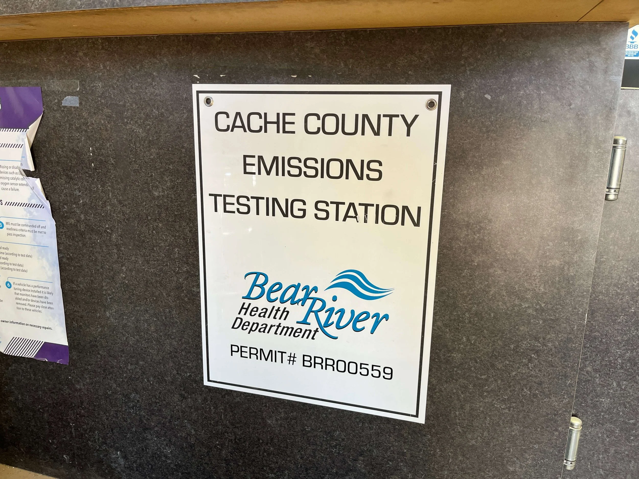 Sign for Cache County Emissions Testing Station with Bear River Health Department logo and permit number.