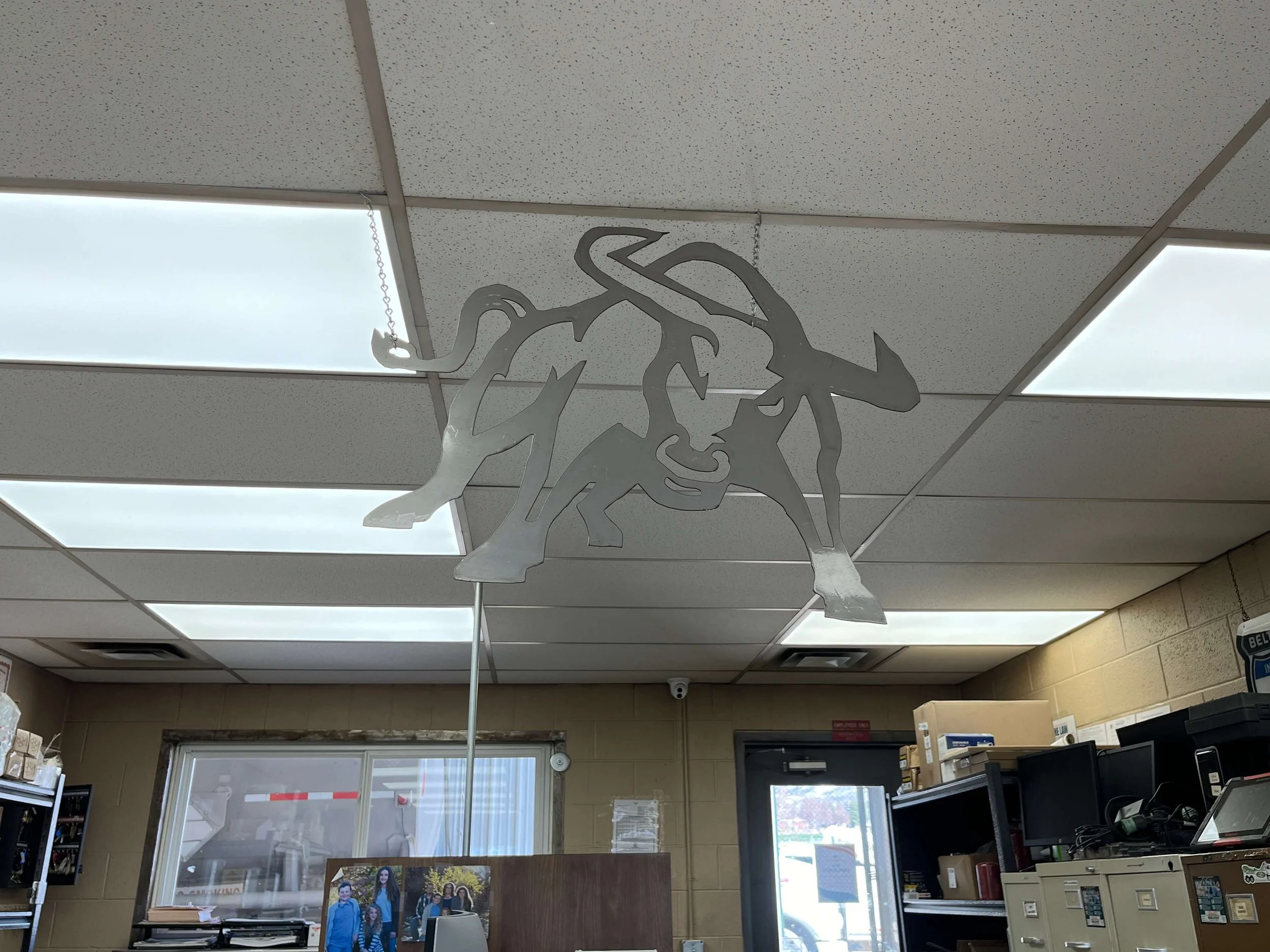 Metal utah state aggie bull silhouette hanging from ceiling in office