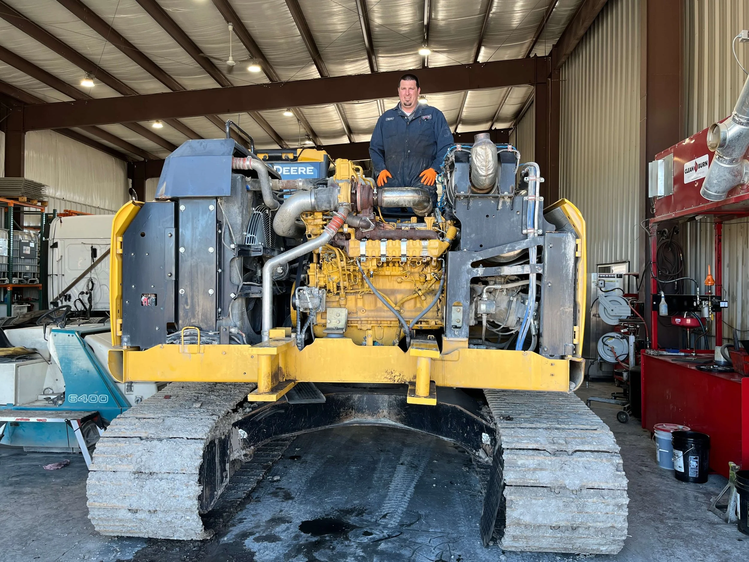 Person standing on a large industrial machine inside a workshop
