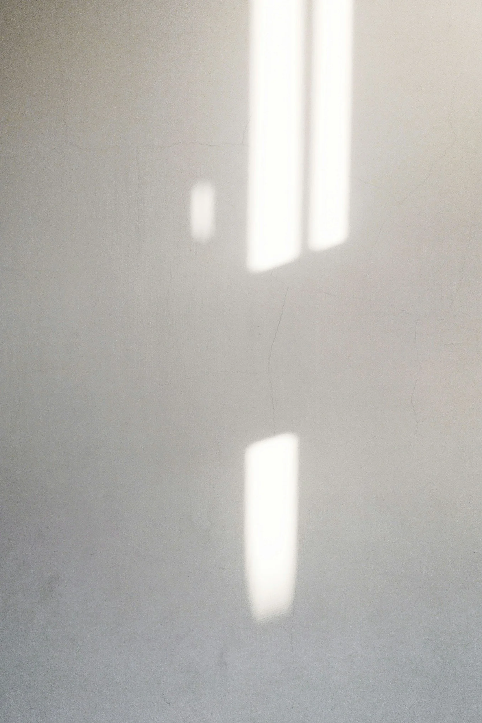 Light reflection on a plain wall with a narrow crack.