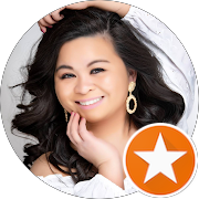 A smiling woman with dark, shoulder-length hair, wearing earrings and a wedding dress, appearing happy and confident.