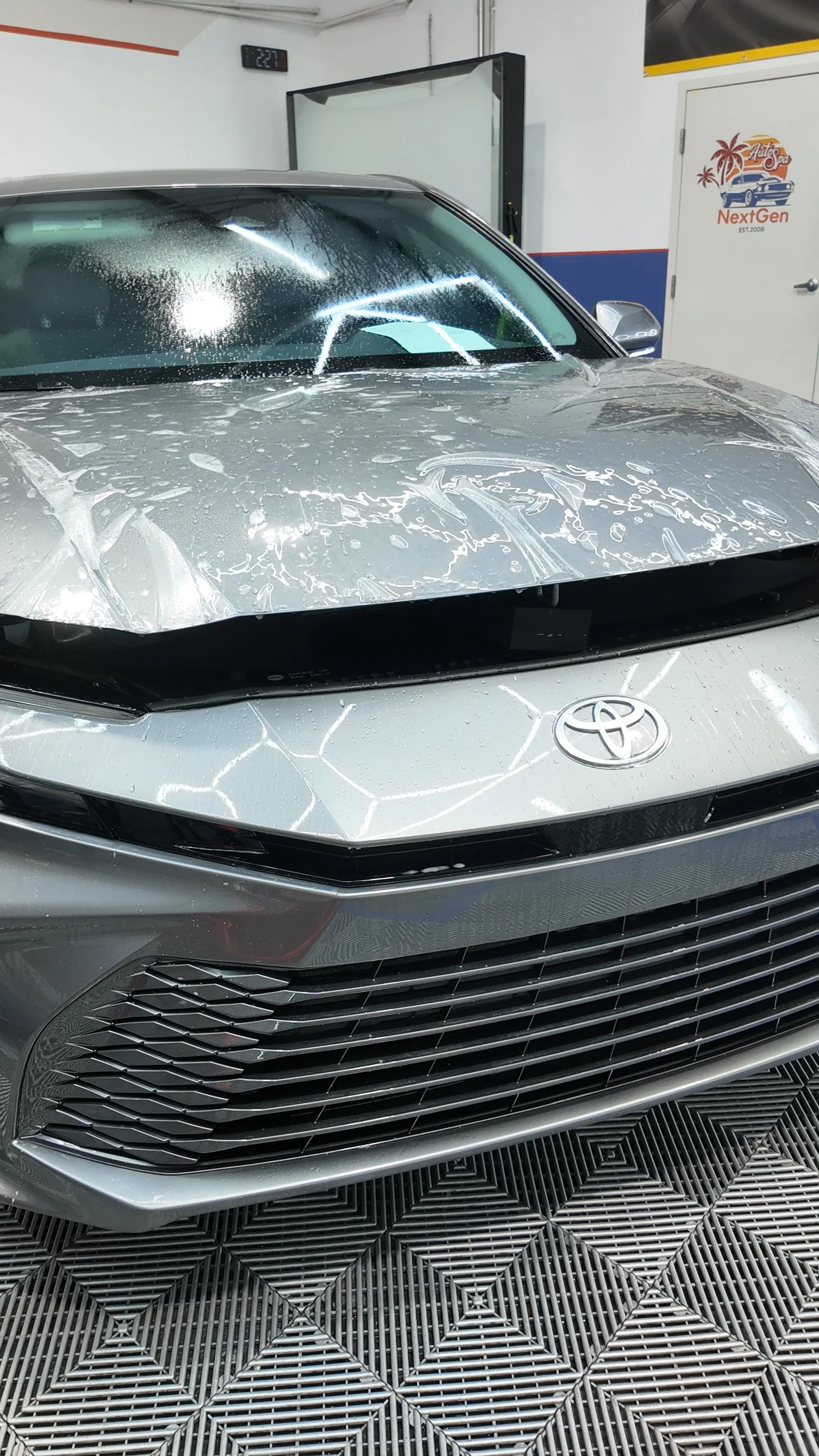 Silver Toyota car inside NextGen Auto Spa, with paint protection film on the front end.