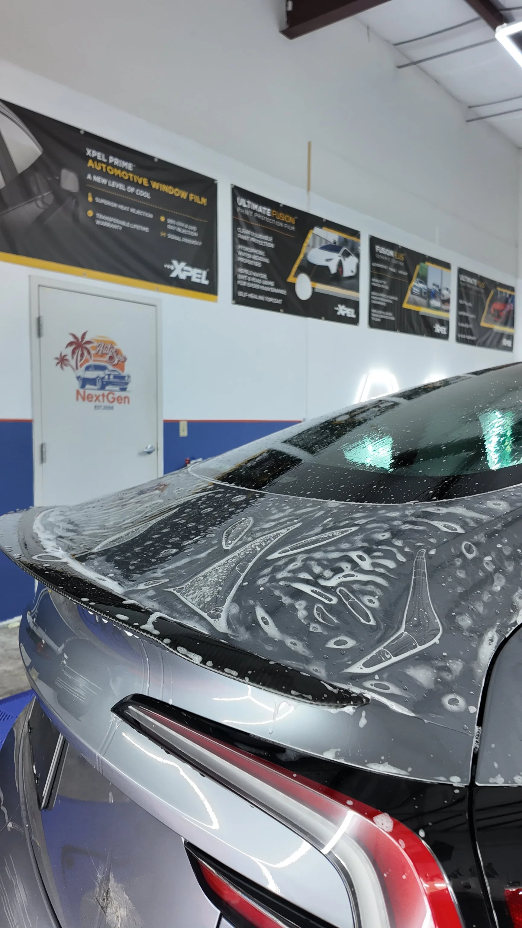 Close-up of a Tesla with paint protection film on the trunk.