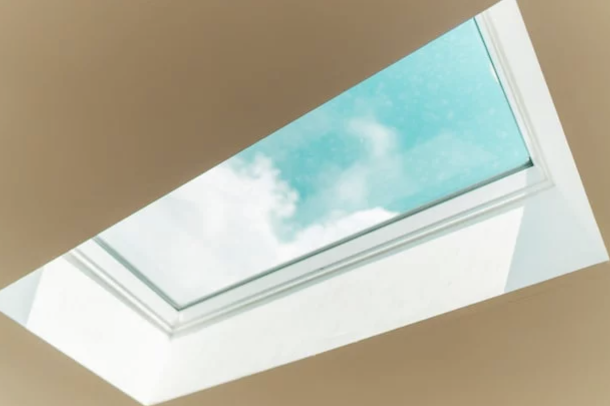 View through a skylight showing a blue sky with clouds