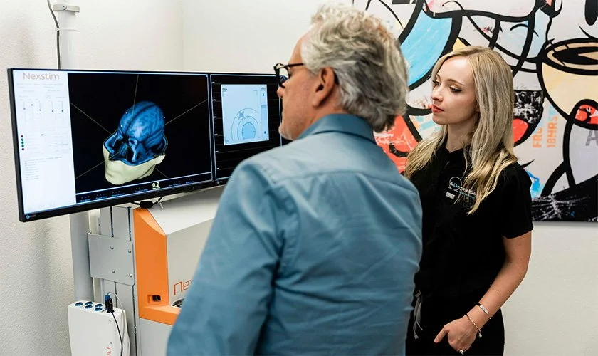 Dr. Reitano consulting with an assistant about Charleston Heights, Las Vegas Transcranial Magnetic Stimulation for Post-Traumatic Stress Disorder.