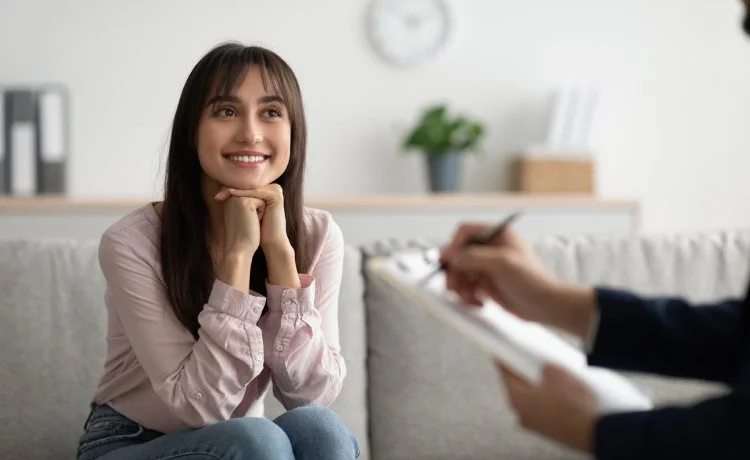 A female patient sitting on a couch during a session with the best psychiatrist near Blue Diamond, Nevada.
