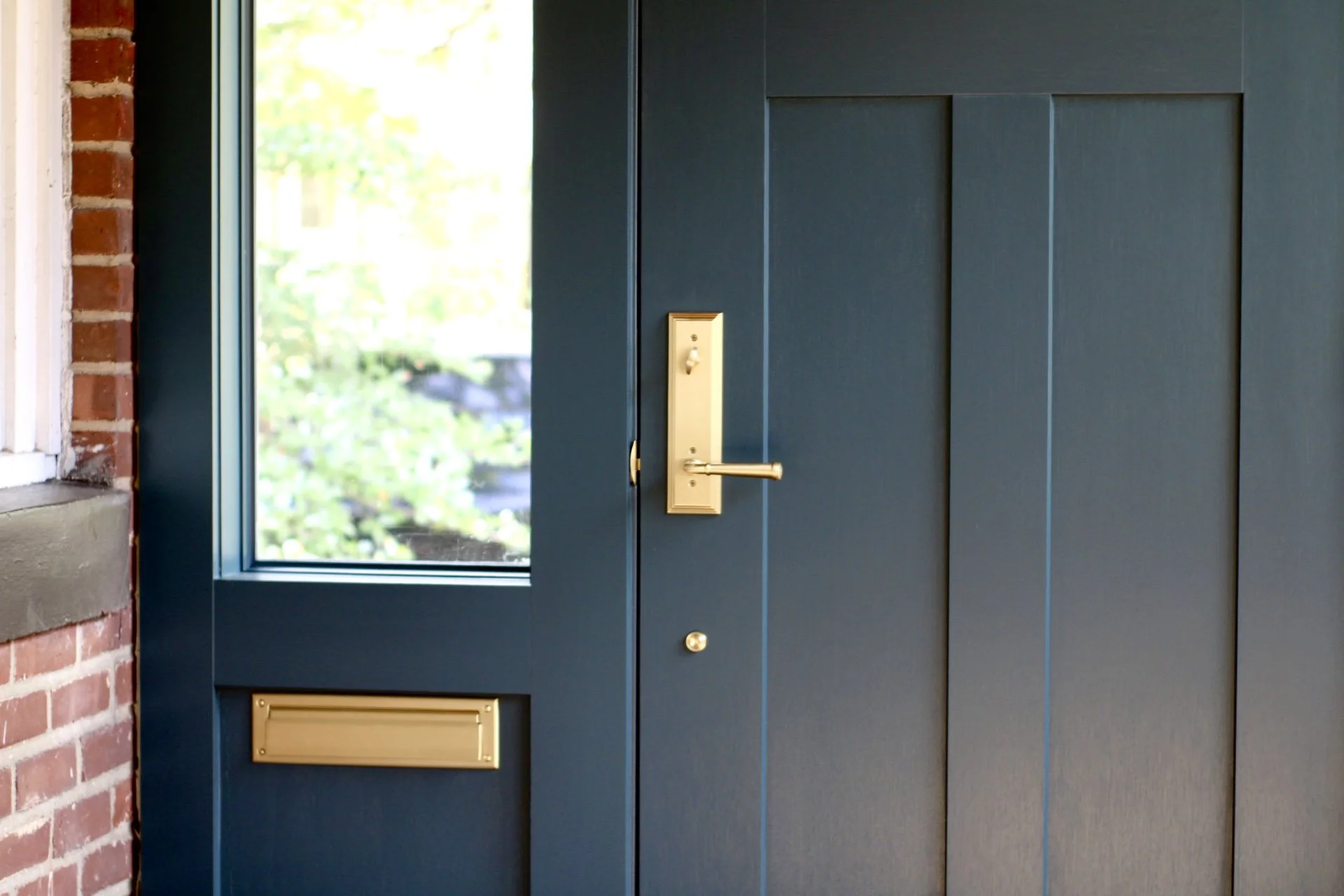 Close up of beautiful gold fixtures on custom front door build and windows. 