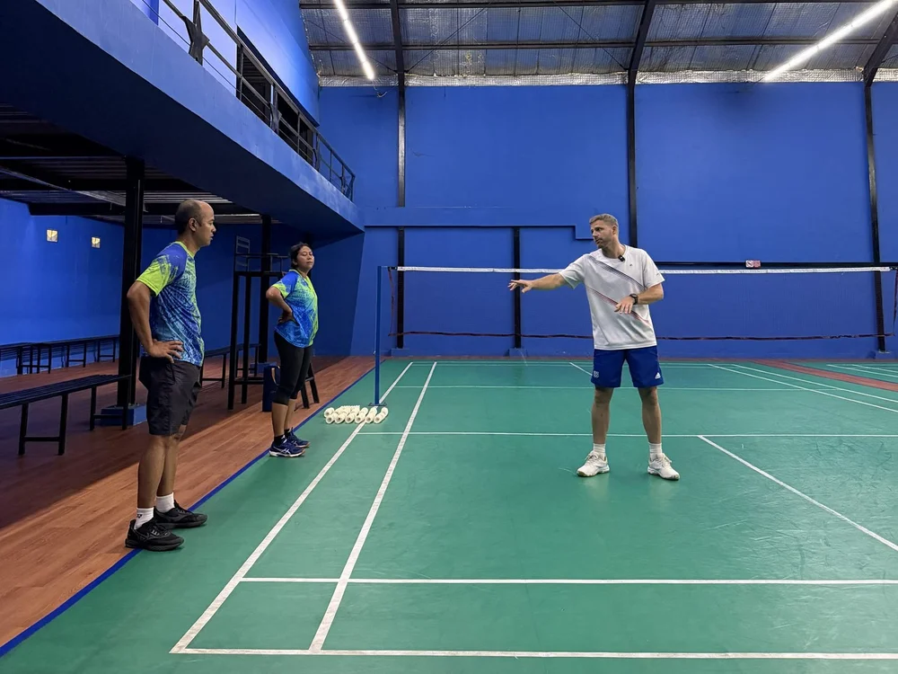 Brice Leverdez explique un geste à deux joueurs sur le terrain