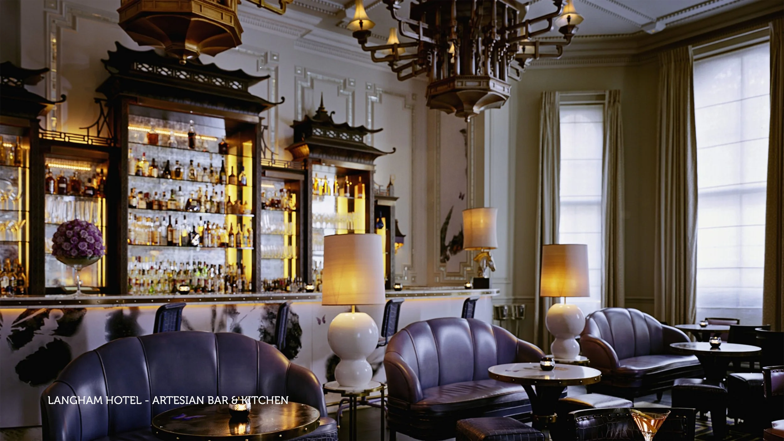 Elegant bar with a marble front, illuminated shelves filled with bottles, decorative lamps, and leather bar stools in a luxurious setting.