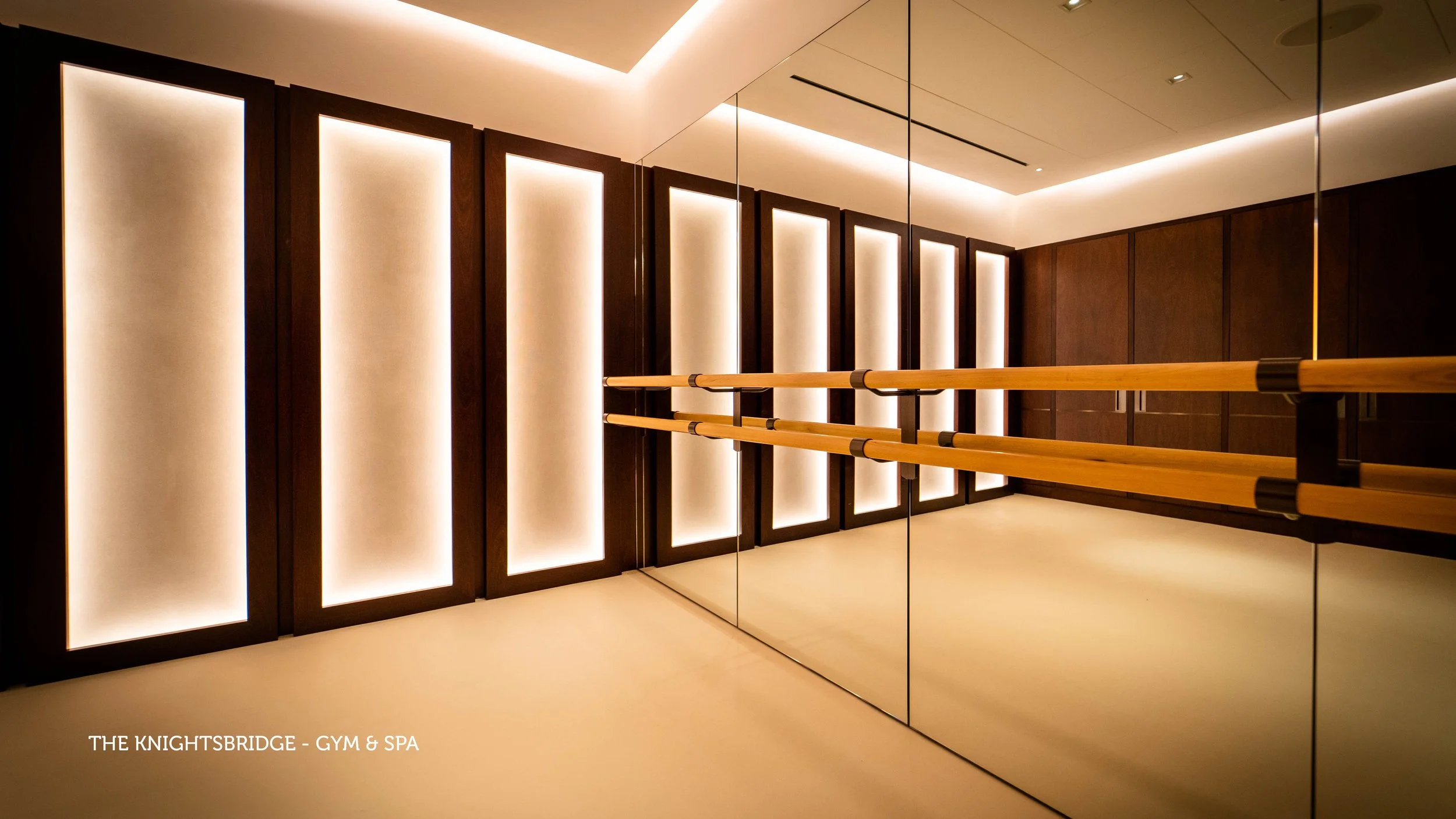 Modern office reception desk with two computer monitors, a black textured wall background, and a minimalist wall decoration in the shape of the number 66, with sleek lighting and black vertical wall panels.