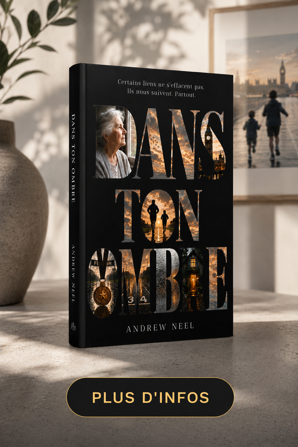Book titled "Dans ton ombre" by Andrew Neel standing on a table. The cover features images of a woman looking out a window, a sunset, people running, a medal, a racetrack, and a house. In the background, there is a blurred framed photo of two children running along the river in London with Big Ben in the distance. A decorative vase is partially visible on the left, and a sign at the bottom says "Plus d'infos."