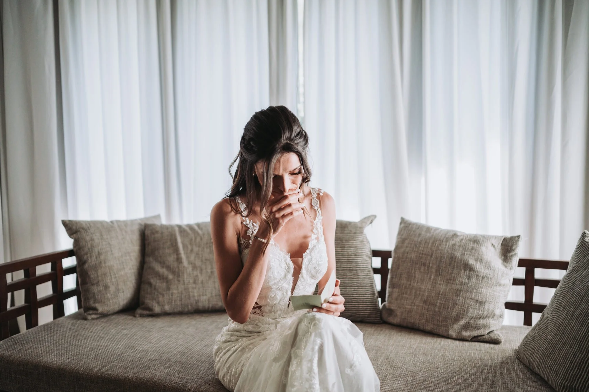 Bride overcome with emotion reading a letter on her wedding morning