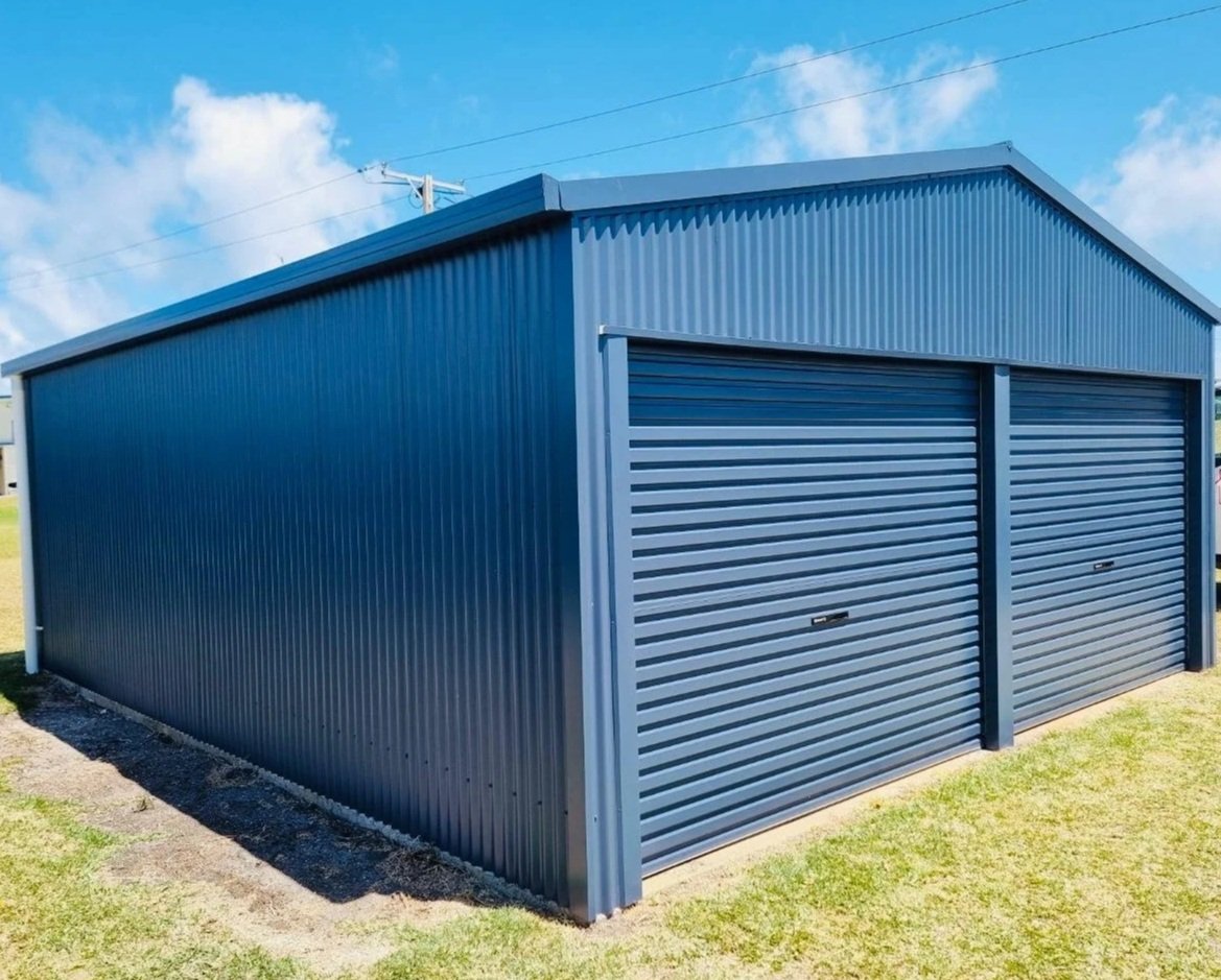 Blue metal storage shed with double rolling doors in a grassy outdoor area.