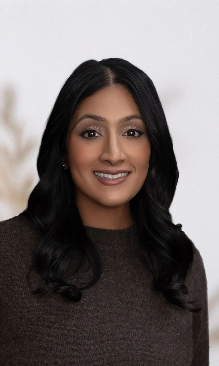 Smiling person with long hair wearing a white shirt.