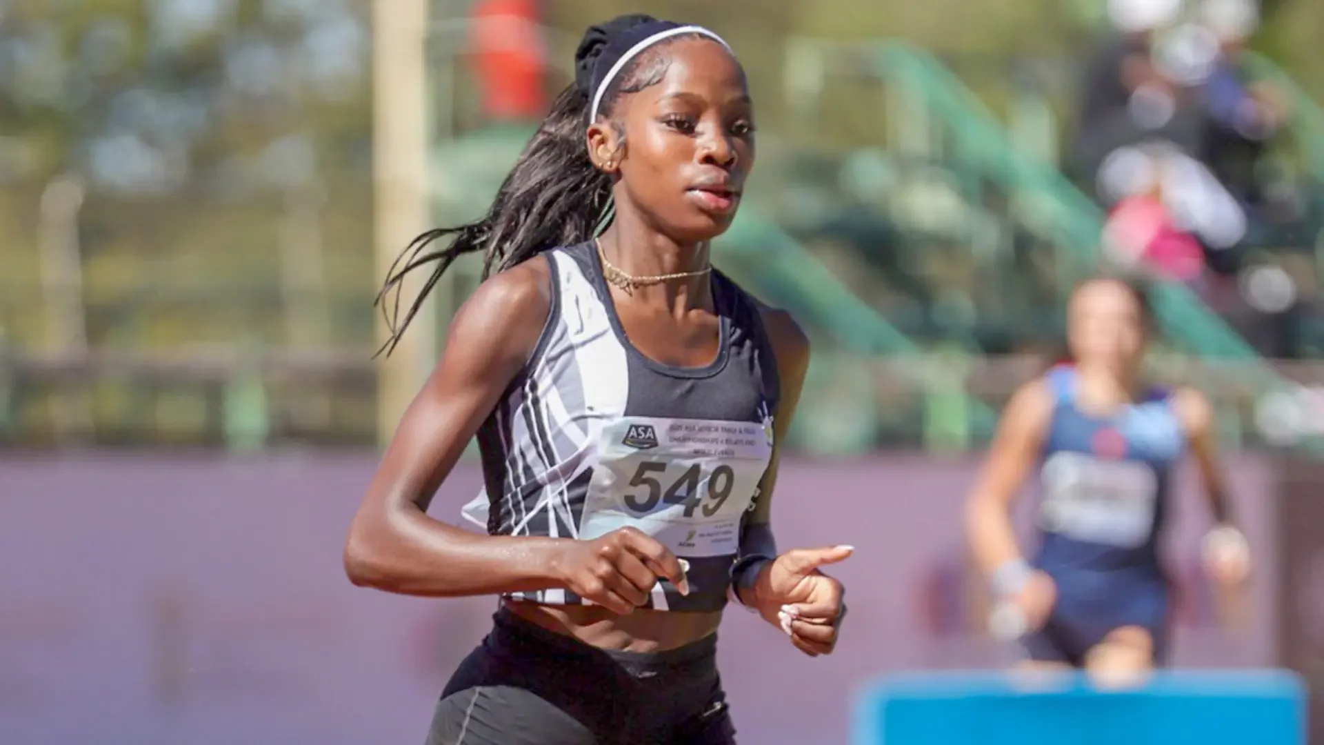 Prudence, running in a race, managed by Livingstone Management Group, wearing a sporty outfit with a bib labeled 'CIAN 315', during an athletic event.