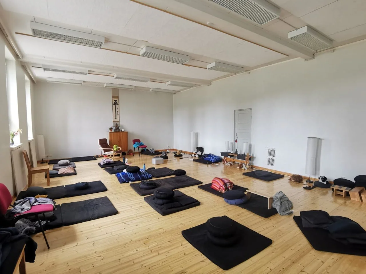 Meditaatiosali jonka lattialla on meditaatiotyynyjä ja meditaatioalustoja.
