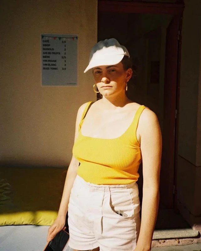 young women with a yellow tank top and a white cap