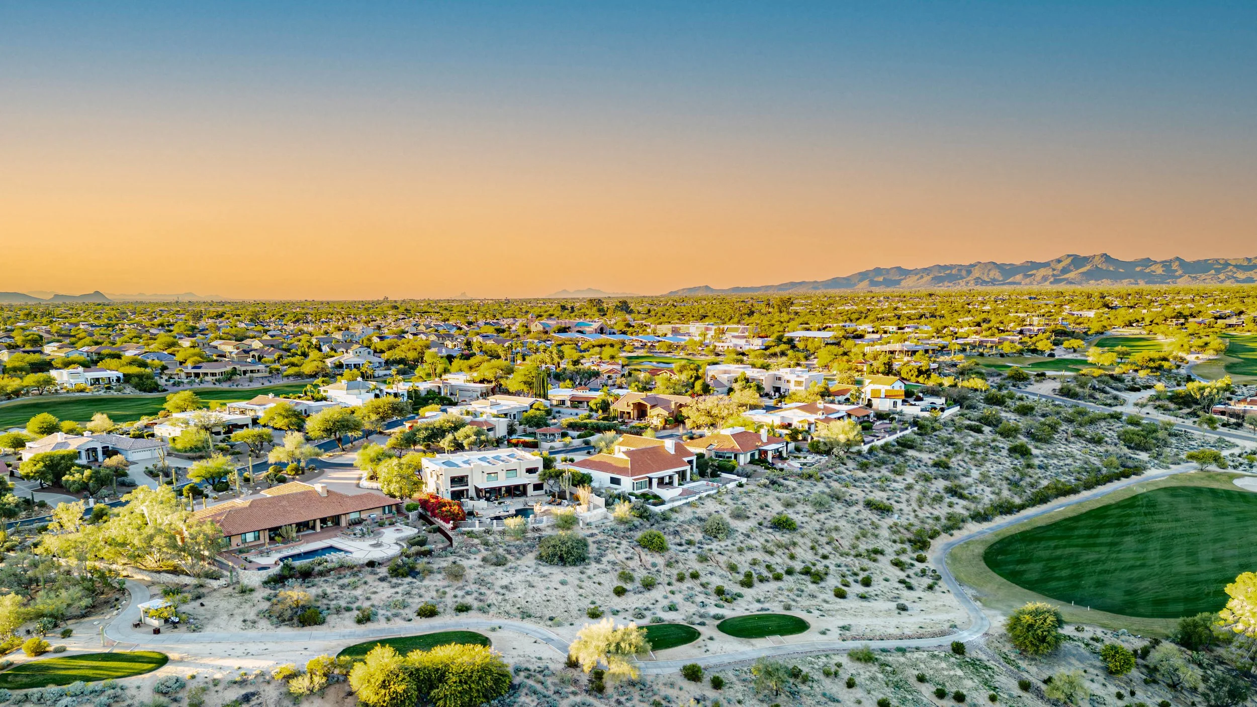 Aerial view of Casas Adobes Tucson Arizona homes with golf course, desert landscape, and mountain views.