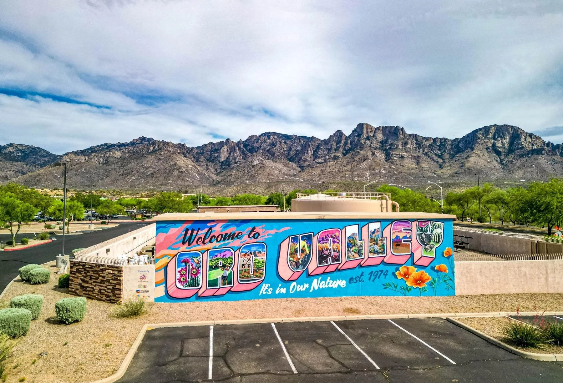 Colorful Welcome to Oro Valley mural with the Santa Catalina Mountains rising behind it.
