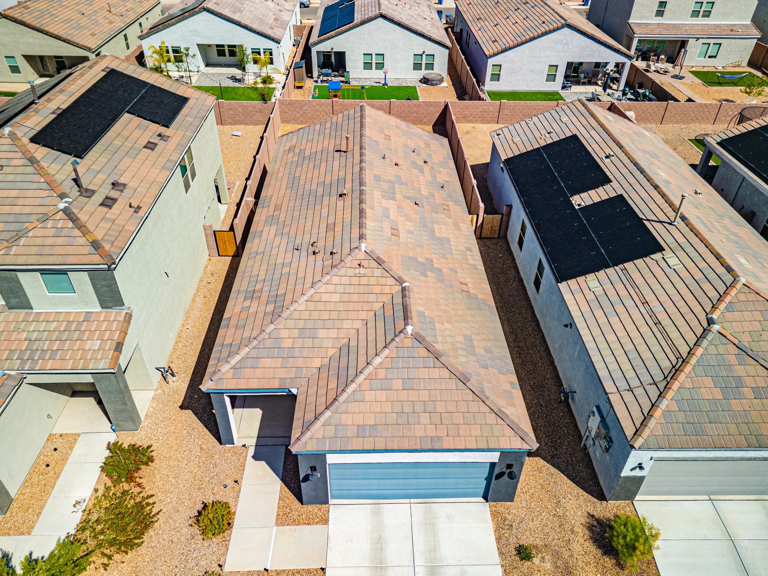Drone aerial view of a single-story home in Vail, Arizona, showcasing the roof, backyard, surrounding neighborhood, and desert landscaping.