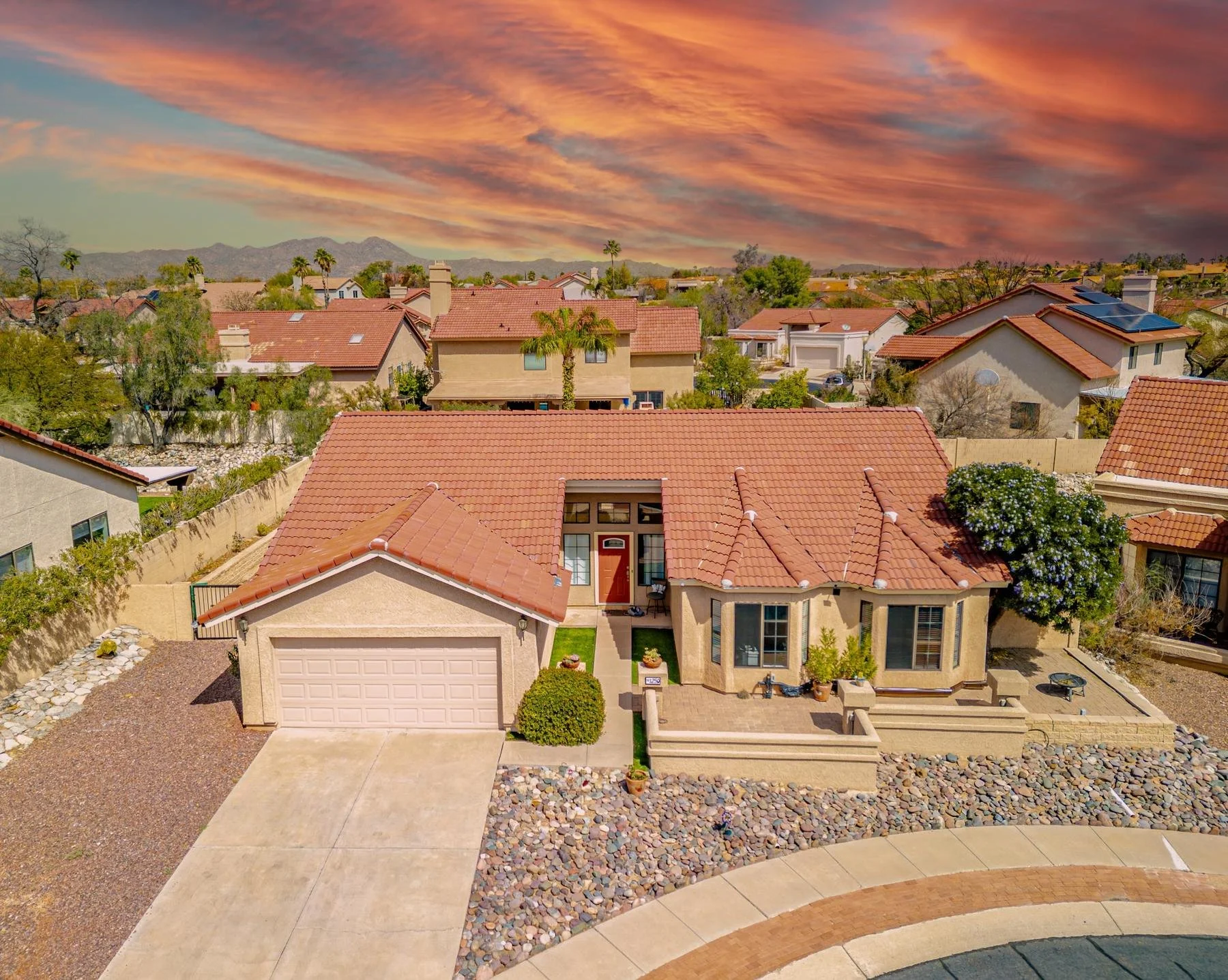 Oro Valley home with a red tile roof, two-car garage, and low-maintenance desert landscaping.
