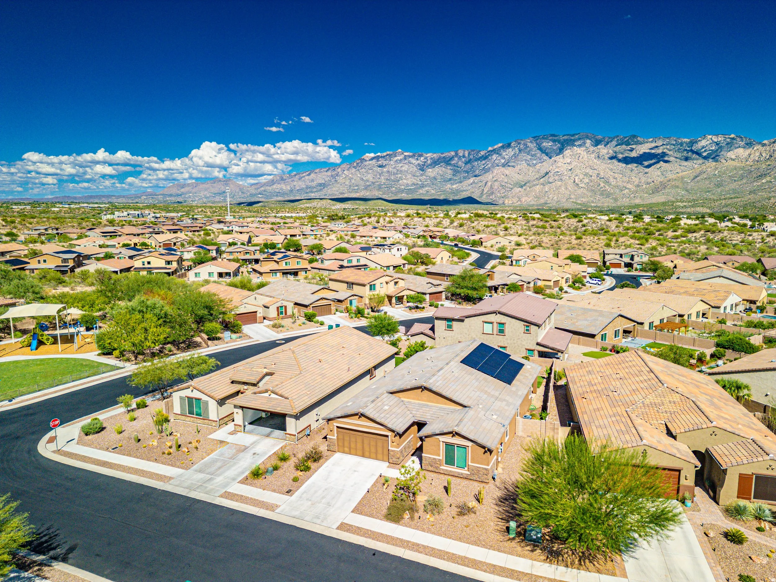 Aerial view of an Oro Valley, Arizona neighborhood with Southwestern homes, desert landscaping, and the Catalina Mountains in the background.