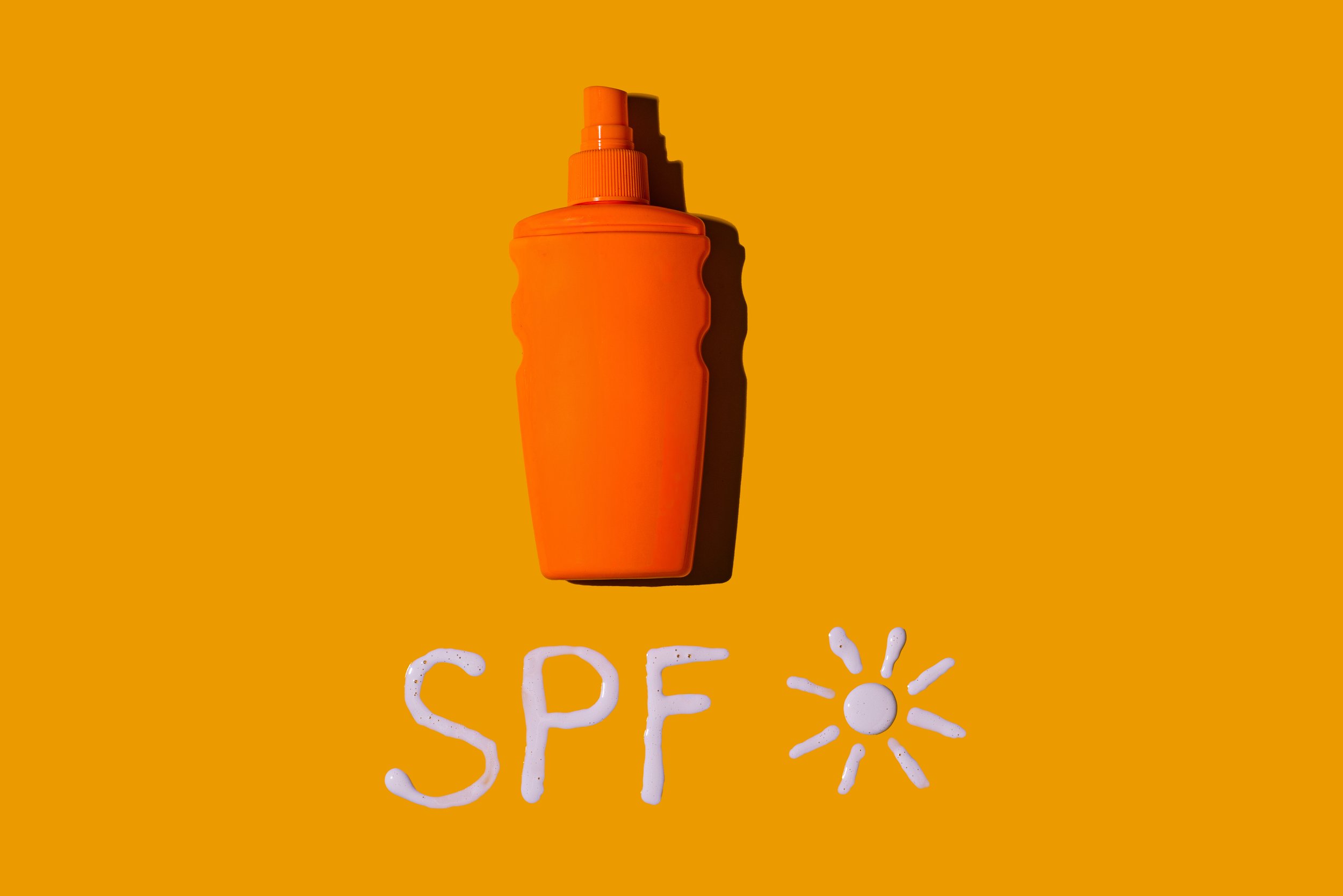 Orange sunscreen bottle labeled SPF on bright background, representing sun safety and UV protection in Arizona.