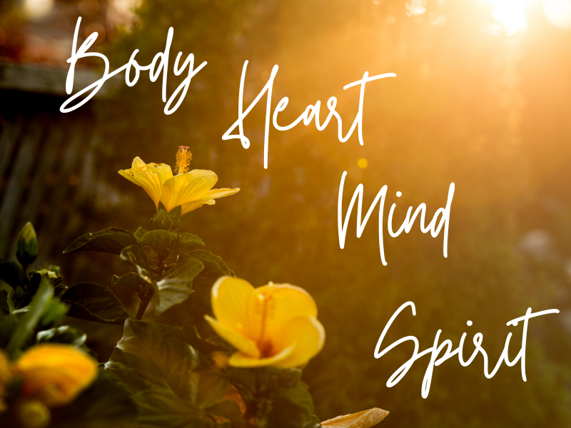Sunset over a garden with yellow flowers, with the text 'Body, Heart, Mind, Spirit' overlaid.