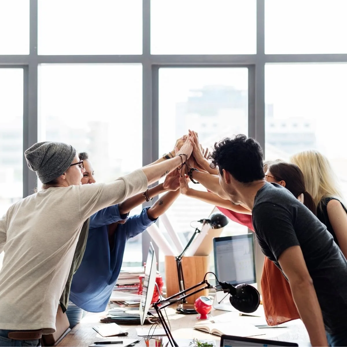 Group of colleagues doing a team cheer in office