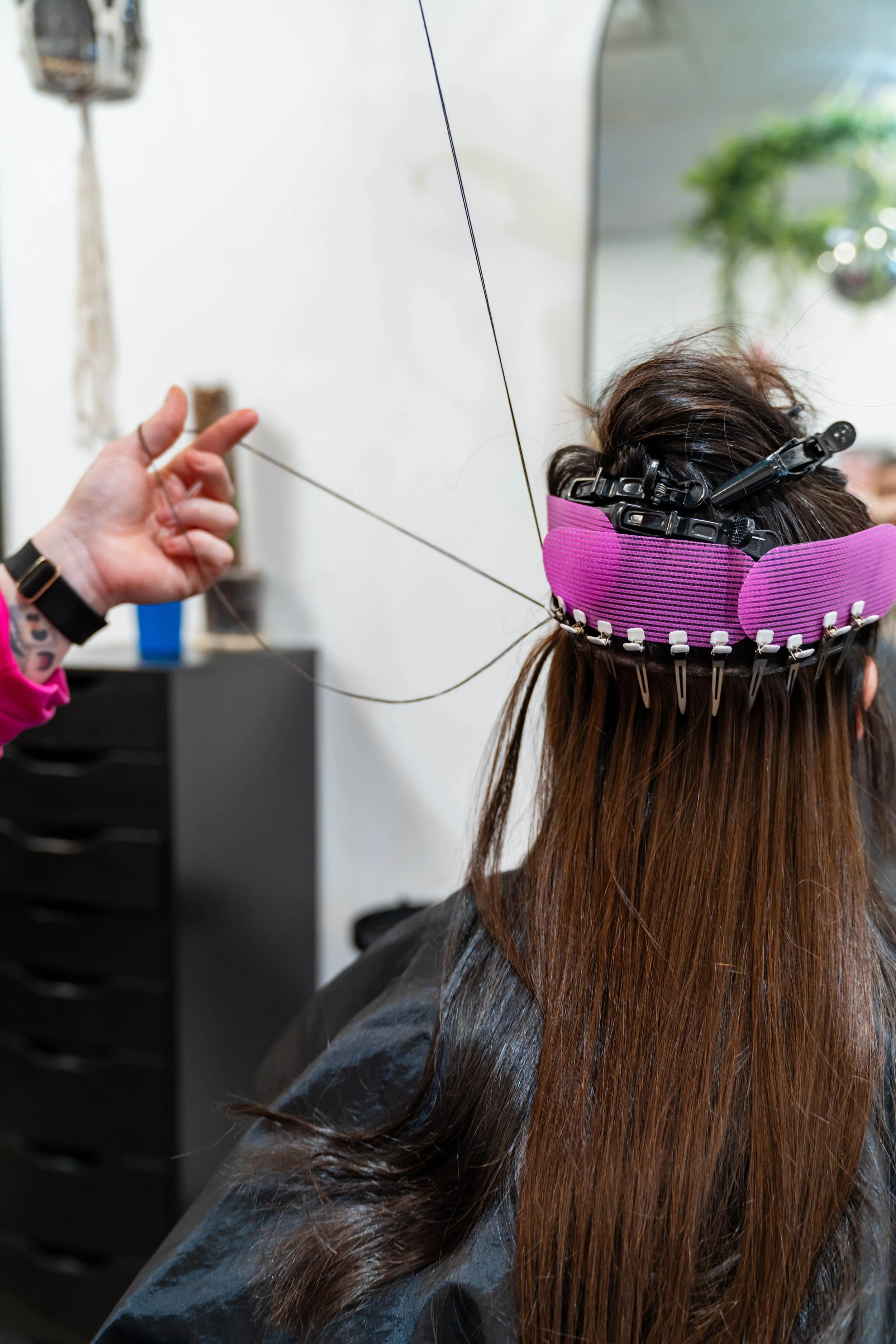 Hair stylist installing hand tied hair extensions at GROW Salon & Spa in Brookside Kansas City