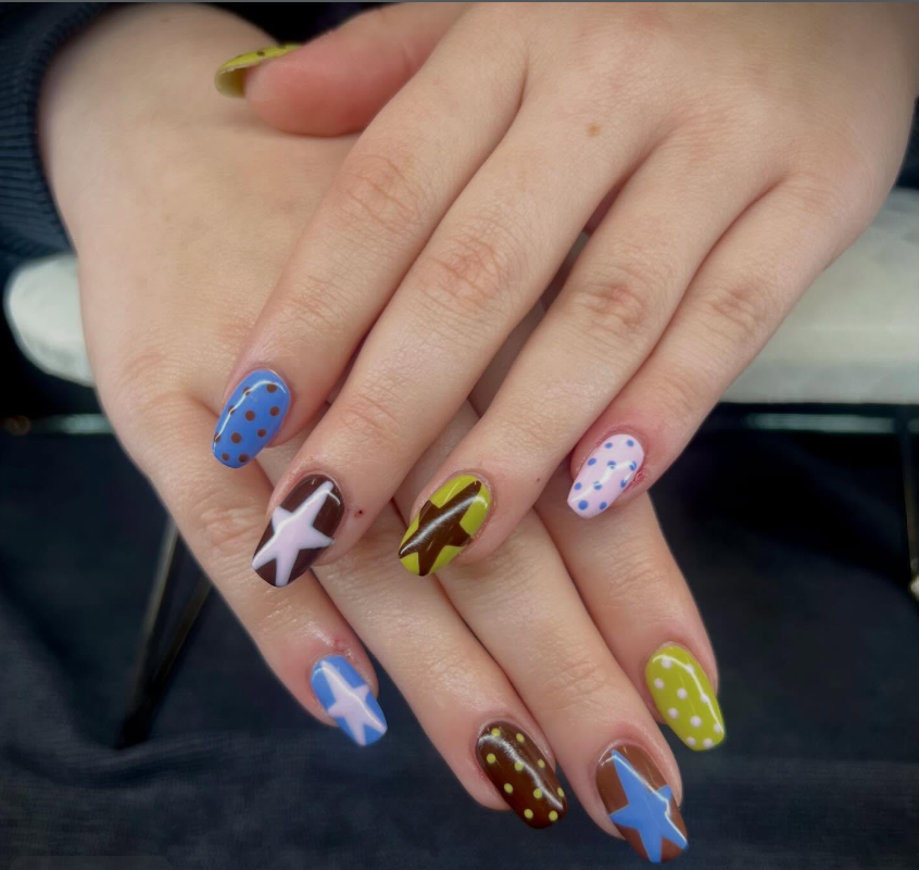 Creative gel manicure featuring mixed nail art designs and vibrant colors at GROW Salon & Spa in Kansas City.