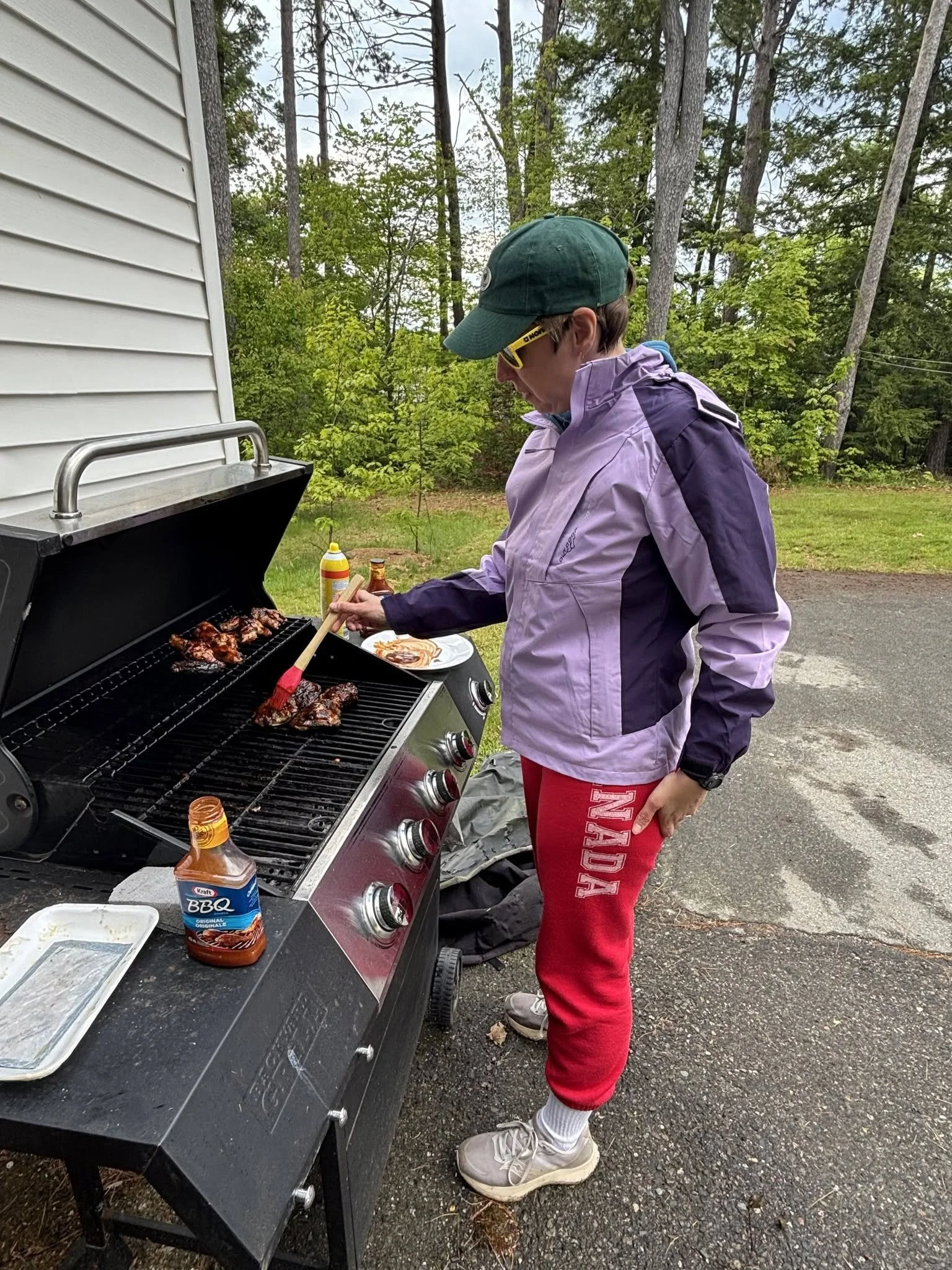 A woman standing in front of a BBQ