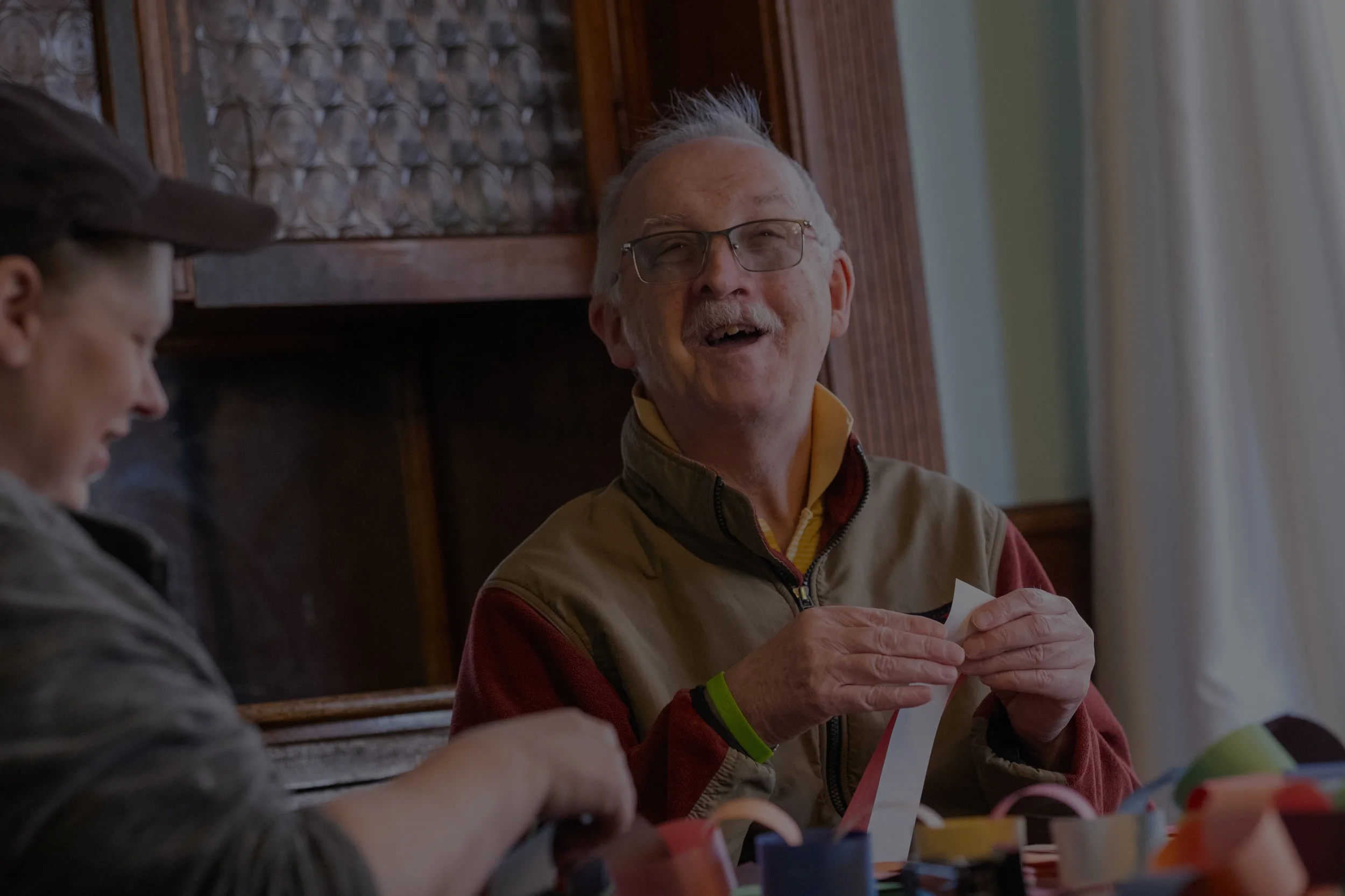 person with diverse abilities doing crafts and smiling