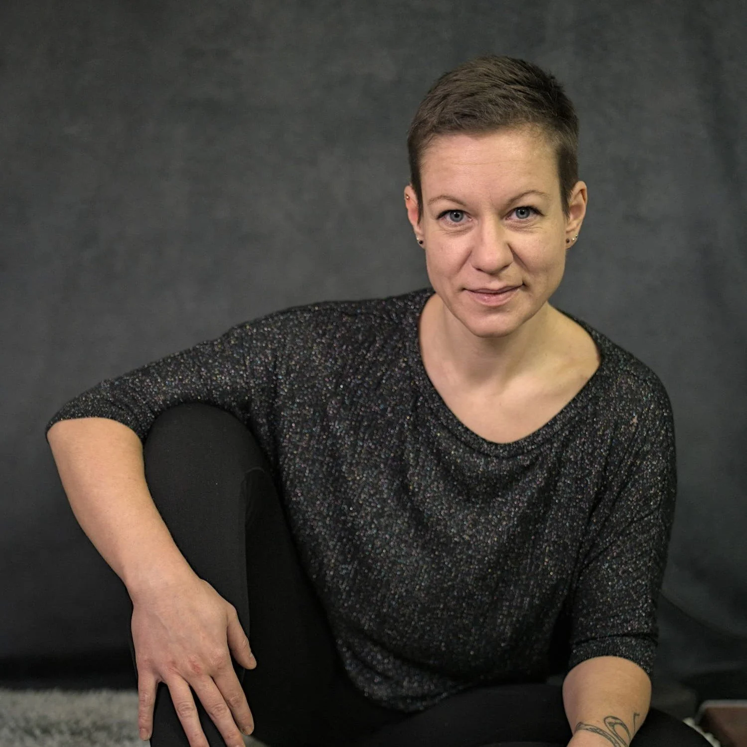 Eva Hanson, Tantra-Masseurin und Berührungscoach, vor grauem Hintergrund