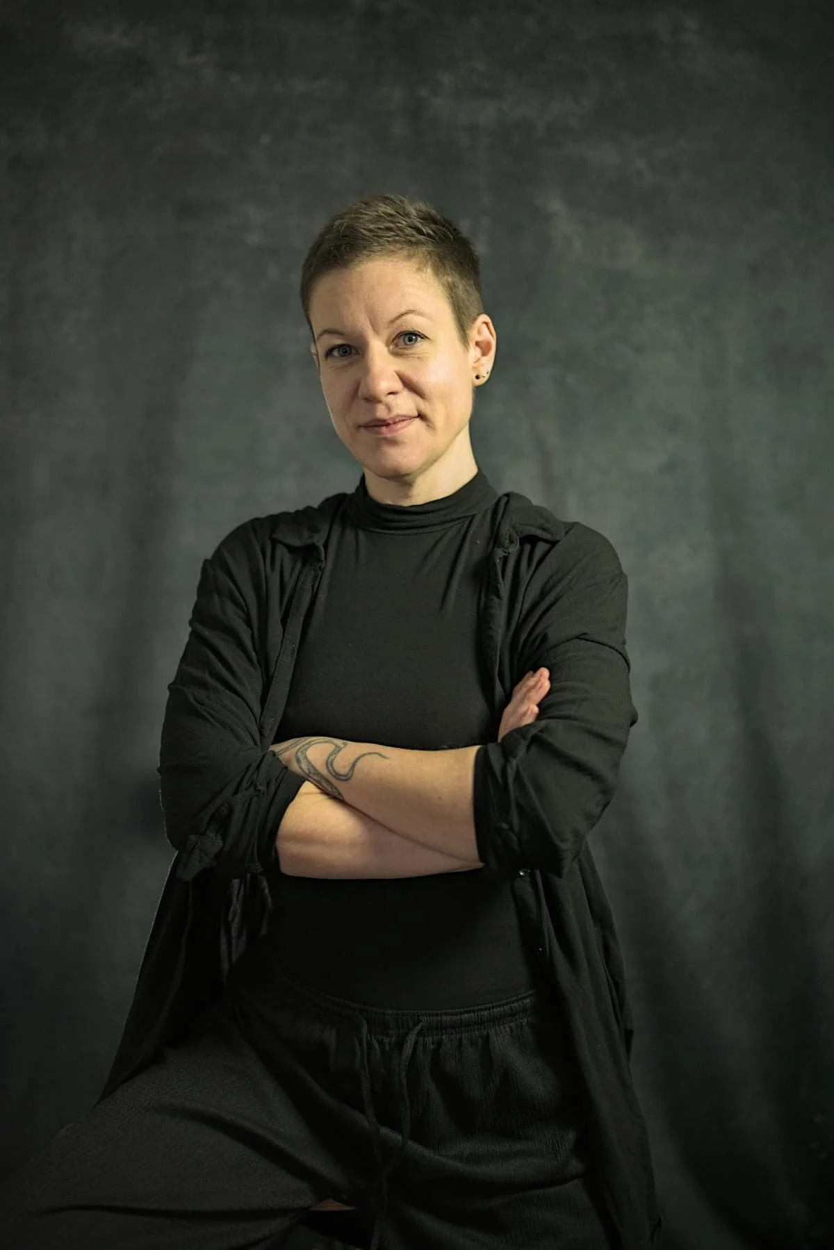 Mentorin für Tantra-Masseurinnen Eva Hanson mit schwarzem Hemd vor dunklem Hintergrund