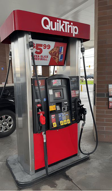 QuikTrip gas pump at a convenience store with a pizza promotion sign on top.
