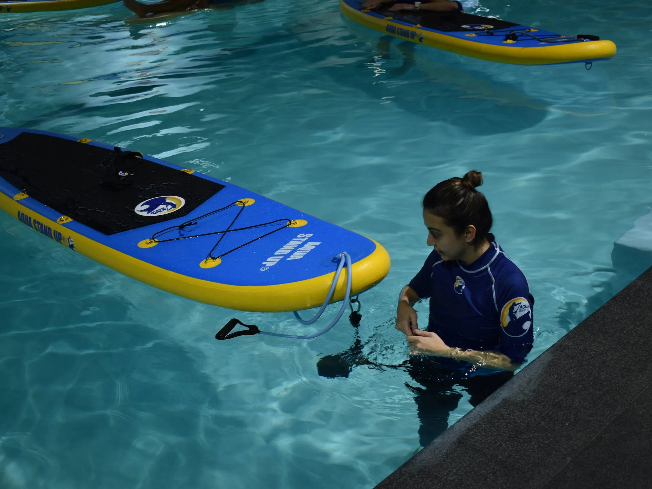 instructor setting up the board in the swimming pool before the class